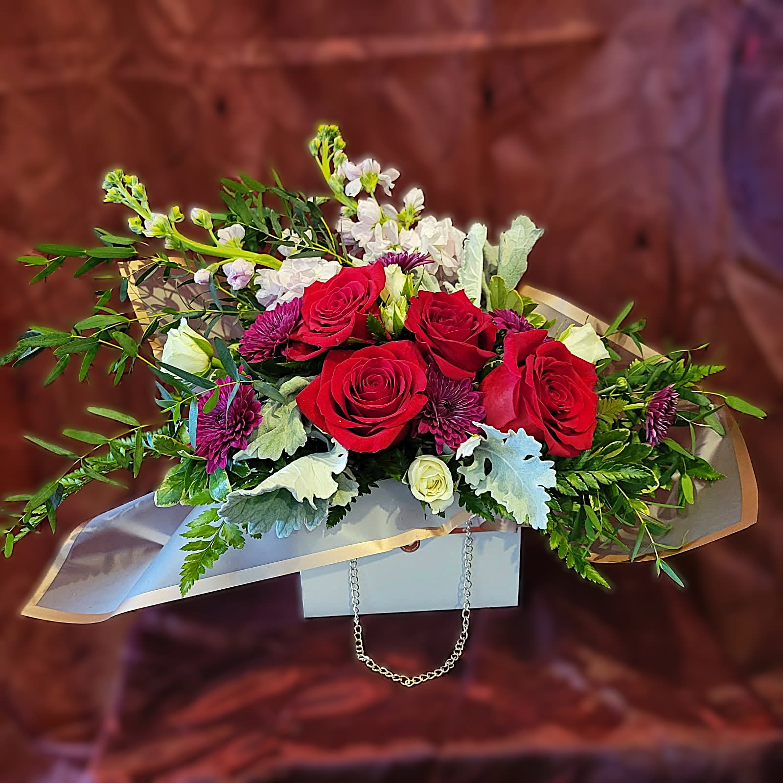 Tote of Love – White - PREORDER - Classic Red Roses with Purple and Lavender accents in our popular purse container! Available after 02/06/2026