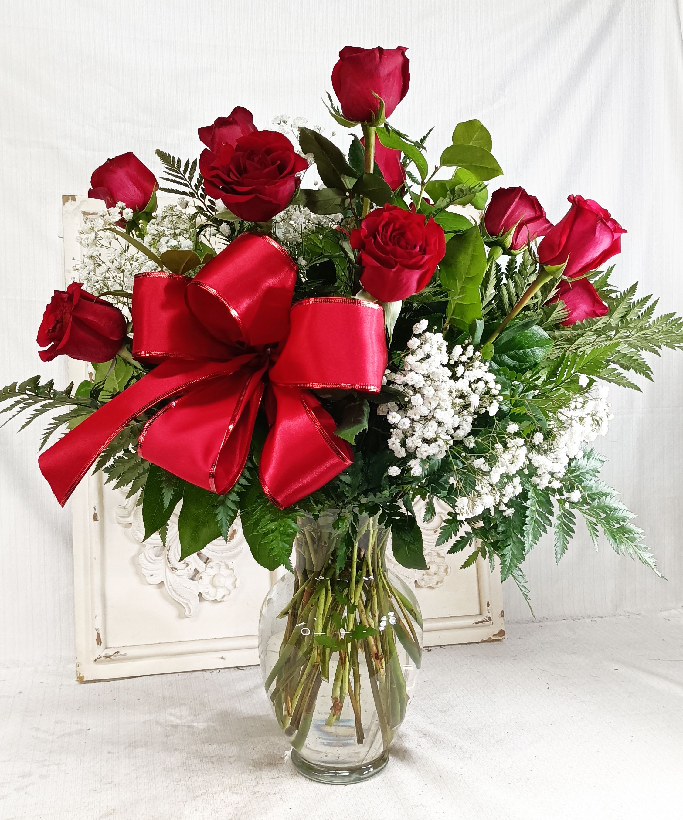 Valentines Dozen - 12 Red Roses, Babies Breath and a mixture of greens with a Valentine Bow!