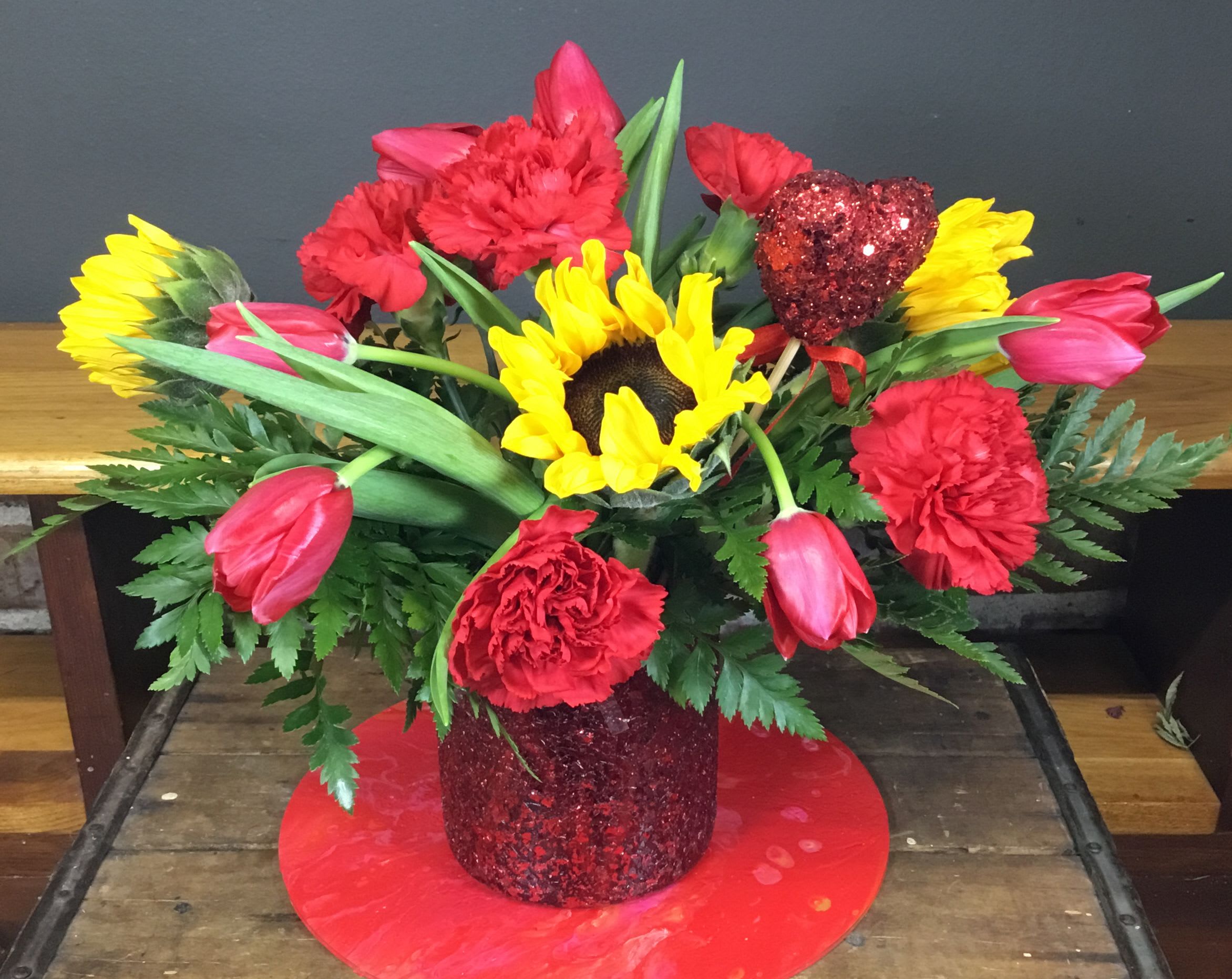 Bee Mine Bouquet - Bee Mine Bouquet in a pretty red sparkly vase with Tulips, Sunflowers and Carnations.