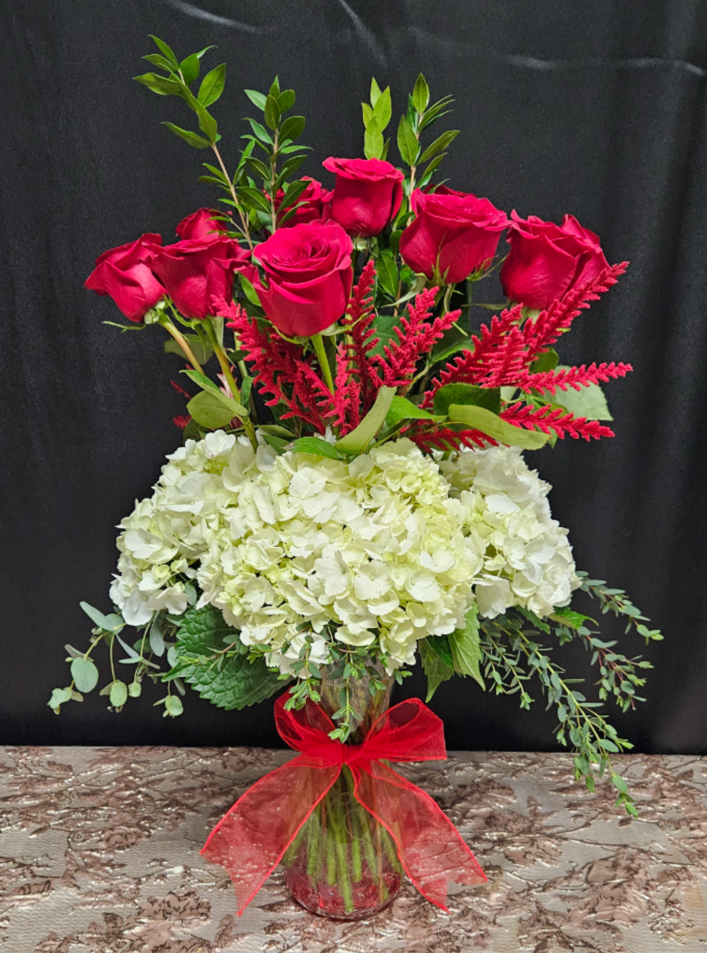 Cloud 12 - Your love reaches above the clouds. A dozens red roses above a cloud of hydrangeas and seasonal greens. Can't go wrong.