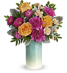 Aqua Allure Bouquet - Just peachy! Celebrate spring or any season, with this lush orange and pink bouquet, artfully gathered in a sunset-inspired peach glass vase with shimmering pearlized finish. Peach roses, dark pink carnations, miniature peach carnations and hot pink matsumoto asters are arranged with dusty miller and huckleberry. This colorful bouquet is delivered in Teleflora's Aqua Allure vase. Approximately 15" W x 17 1/4" H