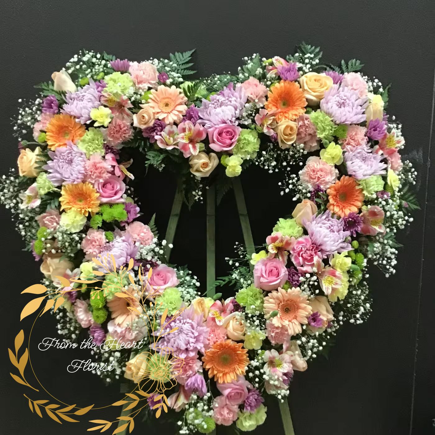 petal love open heart (FH19) - This beautiful open heart made with pink and peach roses, peach gerbera daisy , lavender daisy green and pink carnations, baby's breath and greenery .