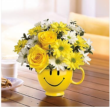 Be Happy Mug Bouquet - When you're looking to make someone smile, this happy face mug of roses and daisies is tops. Sure to cheer up everyone from a beloved wife to a busy boss, these are also great flowers for kids.