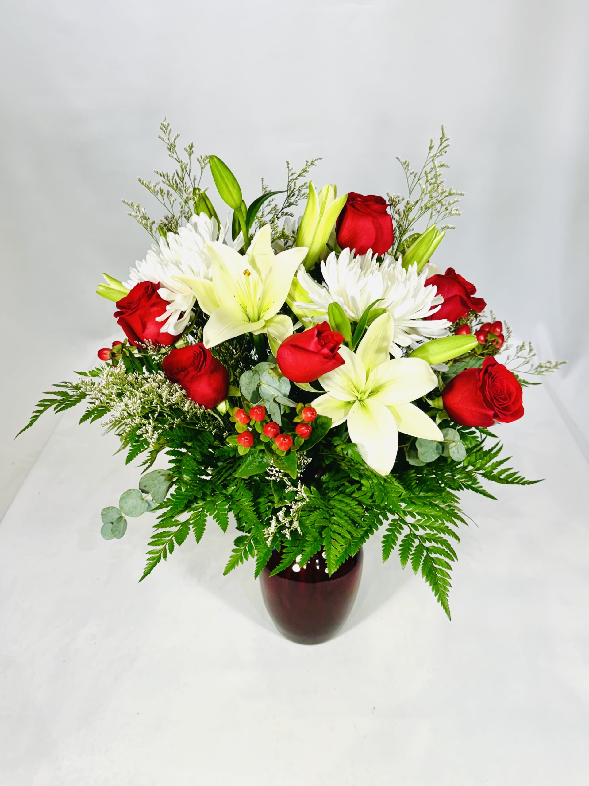 Classic Red Rose and White Lily Bouquet - This fragrant Bouquet includes fresh white lilies, vibrant red roses, red hypericum and white cremones. Accented with lush greens, this bouquet makes a great gift or decoration for any loved one or any occasion!