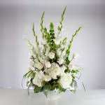 Sweet Comfort  - An all white tribute, this funeral basket is pure and tranquil. Featuring a variety of white flowers and greenery, this design reaches for the sky and evokes a feeling of peace upward and outward. 
