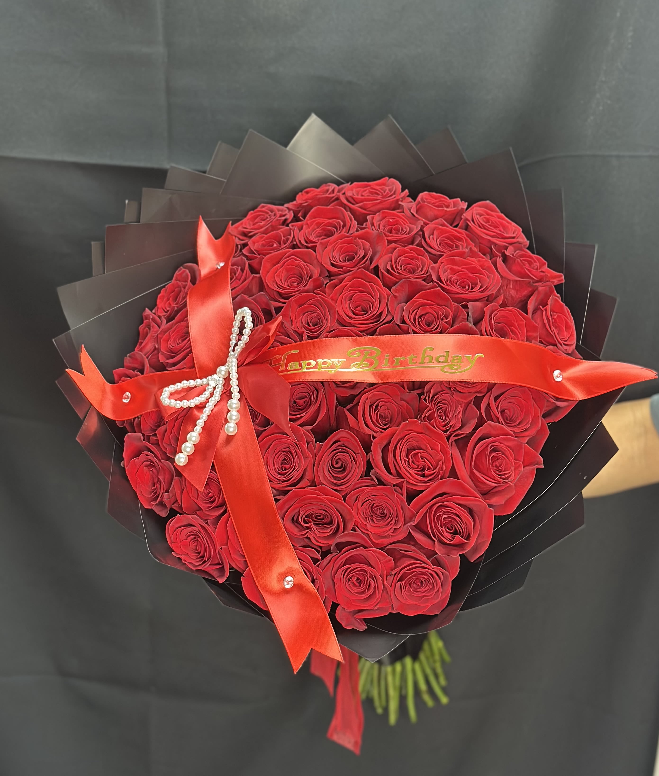 All Rose Bouquet (50ct.) - 50 roses arranged into a round bouquet with the color paper of your choosing and color of rose of your choosing. Accessories included.