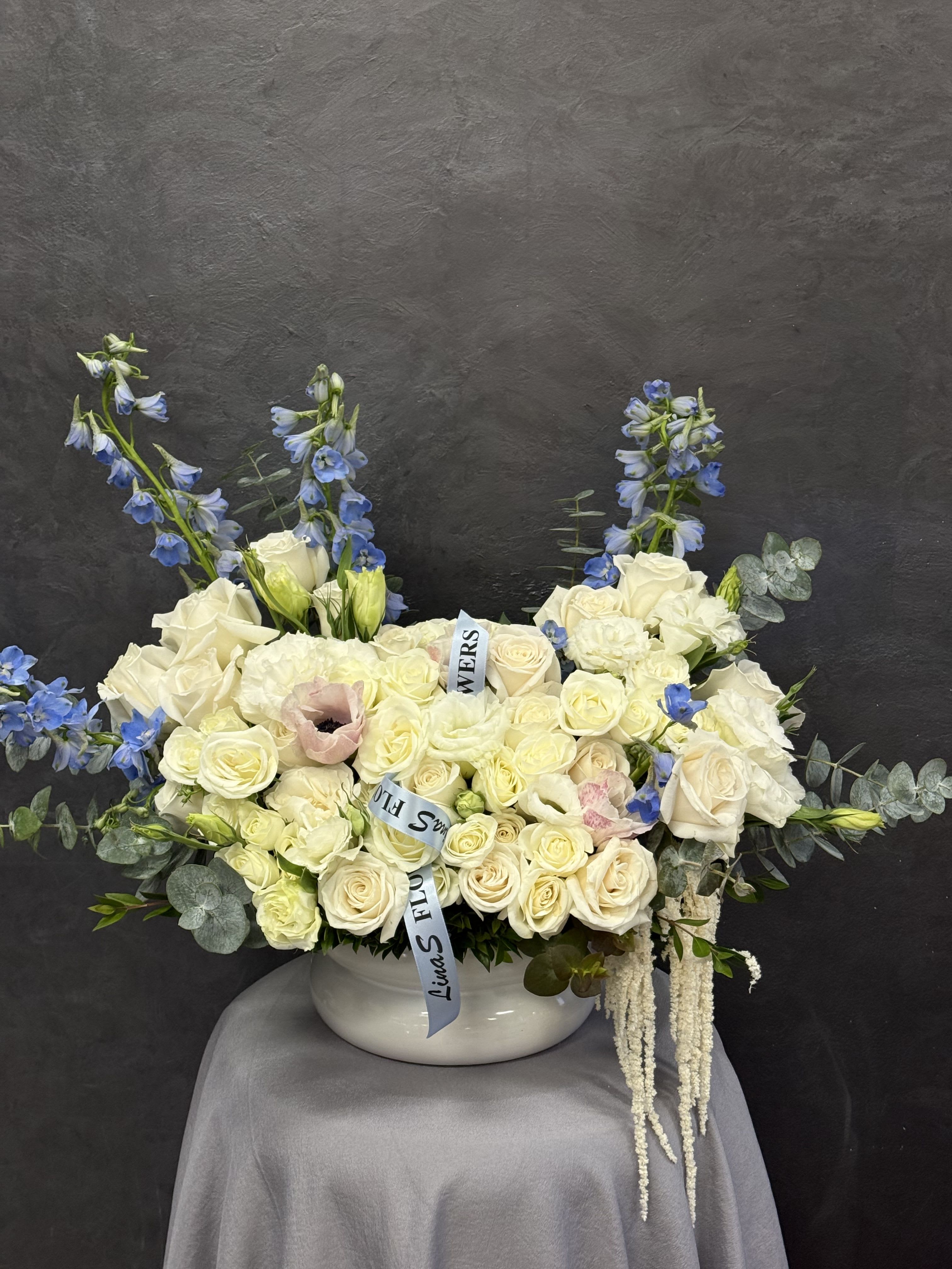 Areg - Soft white roses and airy blue delphinium, whispering calm, grace, and refined beauty
