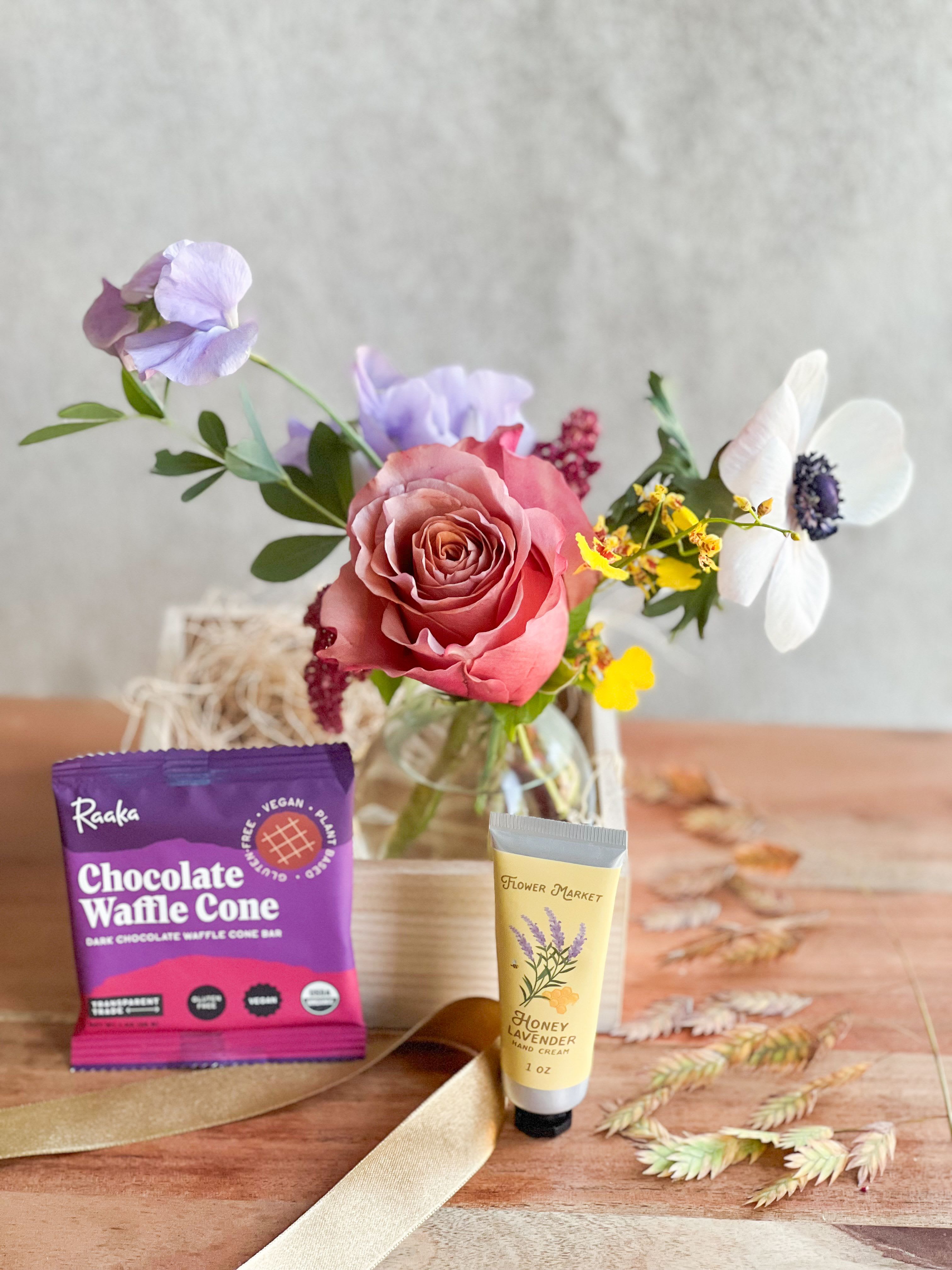 A Little Pick Me Up - A bud vase seasonal  arrangement paired with a hand cream by Panier Des Sens, a sea salt chocolate bar, a keepsake wooden box and a handwritten card. 