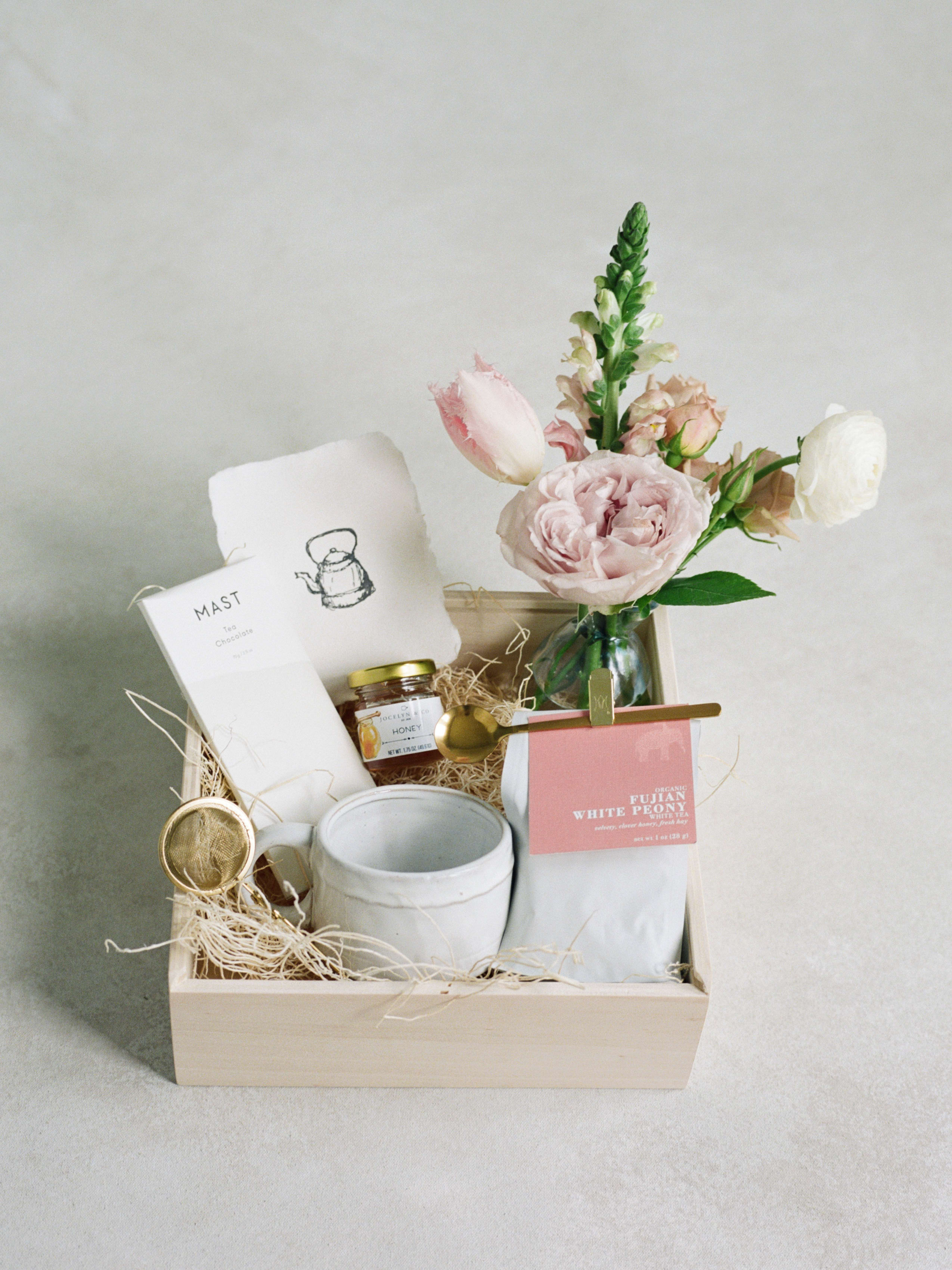Tea Time  - A gift box for our Tea Enthusiast.  -Small Bud Vase Arrangment - A Tea Chocolate Bar by MAST - Small jar of Honey - Ceramic Cup - White Peony Tea  - Gold Tea Spoon - Gold Tea Infuser  - A Handmade Card  - Wooden Keepsake box 