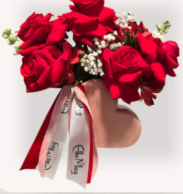 Heavy Heart - Heavy Heart  Rich in meaning, Heavy Heart is a sweet and romantic arrangement designed in a charming heart-shaped vase. Featuring classic red roses accented with soft filler blooms and finished with a signature ribbon, this piece is perfect for making a heartfelt gesture without saying a word.  Ideal for Valentine’s Day, Galentine’s, or a thoughtful “just because” moment, Heavy Heart delivers love in its simplest, most beautiful form.  Details  One Size – $50  Designed in a heart-shaped vase  Vase Color Options  Red  Blush Pink  Please leave your vase color choice in the Florist Notes during checkout.