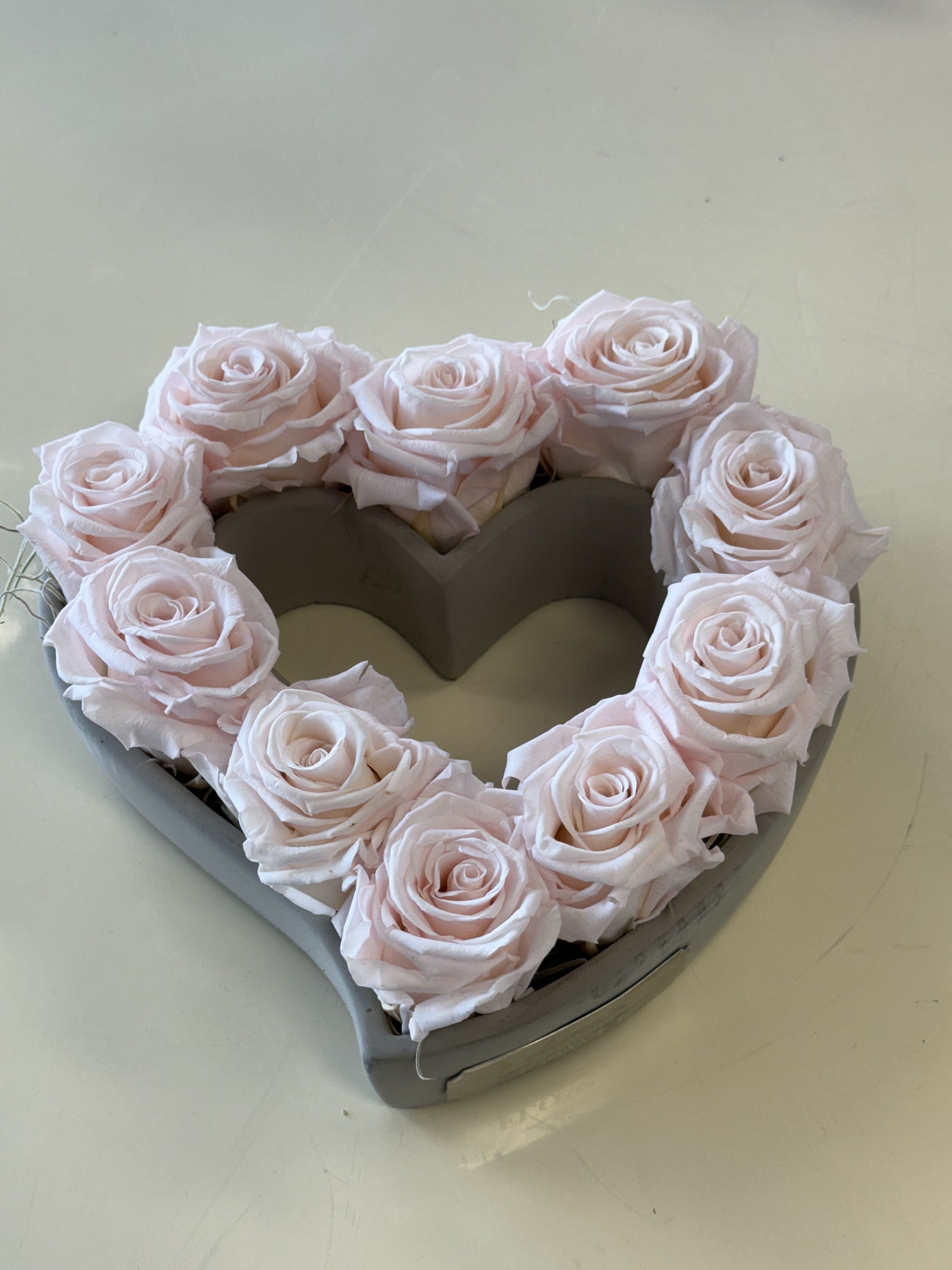 Preserved light pink heart  - Preserved light pink roses are real roses that have been delicately treated to retain their soft color and natural beauty for an extended time. Symbolizing grace and admiration, they make a timeless and elegant gift that requires no maintenance.