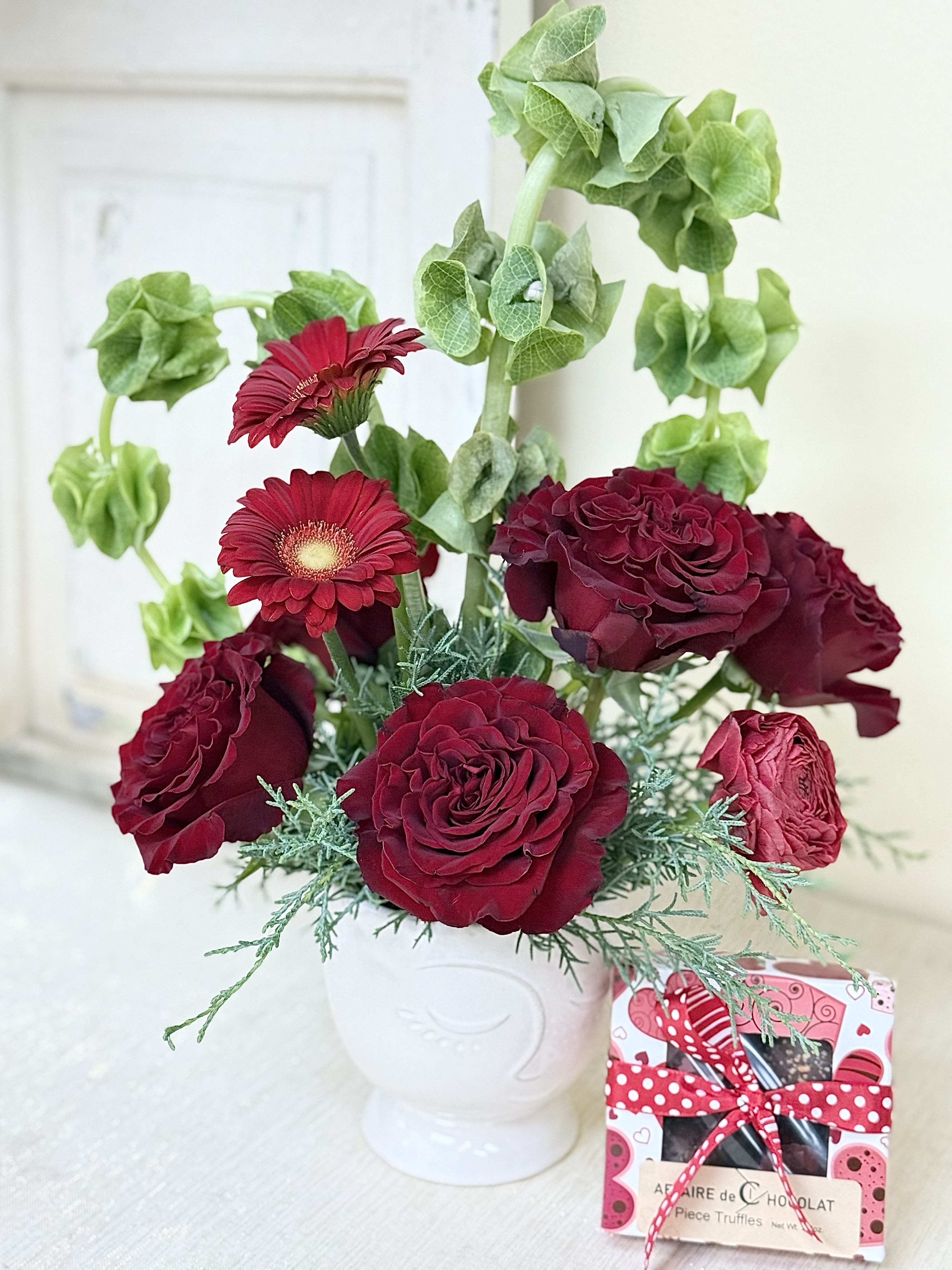 Love you - A interesting face container with red roses and other blooms with a heart of greens. We have added a box of truffles