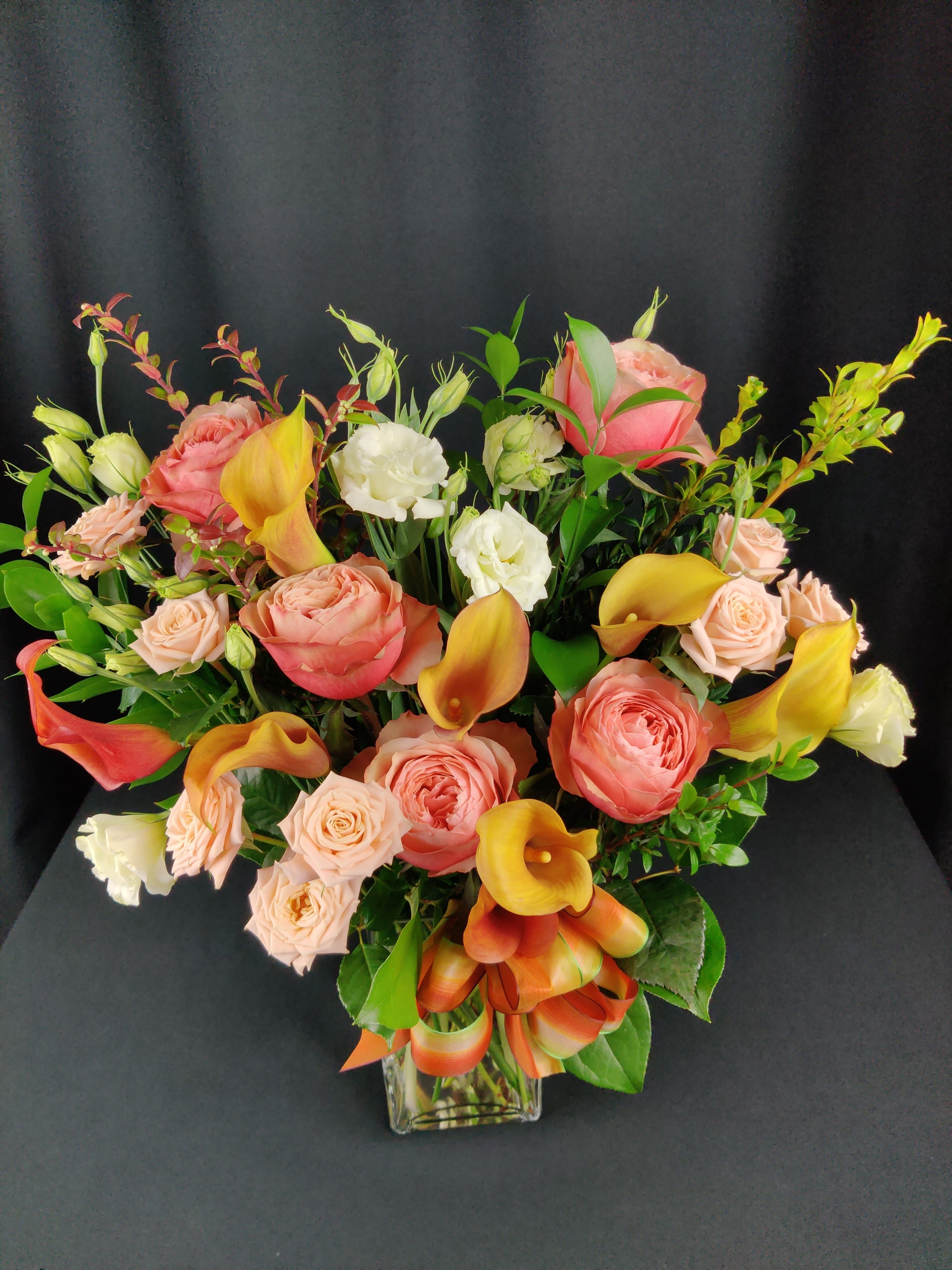 Callas and Roses - Premium combination of calla lilies and roses arranged in an elegant style where LESS IS MORE. Colors and flowers may vary. Order well in advance, especially if requesting specific colors.  Perfect for a wedding anniversary or engagement.