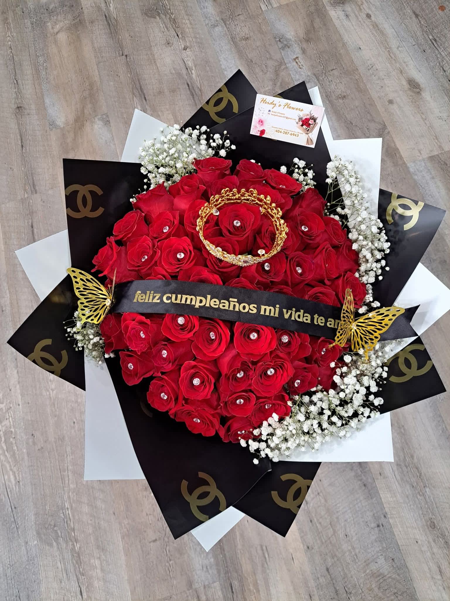 Channel 50 red roses. - A bouquet of 50 red roses with baby's breath, a crown, and a personalized ribbon. Wrapped in paper, this large, elegant bouquet is perfect for expressing love and passion.