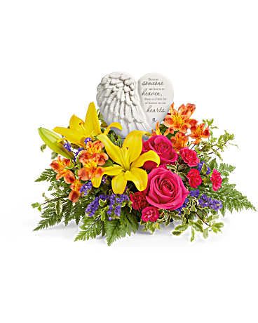 Forever In Bloom Bouquet Keepsake Heart - A heartfelt tribute to a cherished life, this stunning arrangement of vibrant blooms beautifully surrounds Teleflora's Heaven's Heart Keepsake. Featuring a delicate angel wing design, this touching porcelain keepsake offers comfort and love, making it a treasured reminder of precious memories. This arrangement features hot pink roses, yellow Asiatic lilies, orange alstroemeria, hot pink miniature carnations, purple sinuata statice, leatherleaf fern, and pitta negra. Arranged with Teleflora's Heaven's Heart Keepsake, this beautiful tribute offers comfort and remembrance. Approximately 17 1/2" W x 14" H