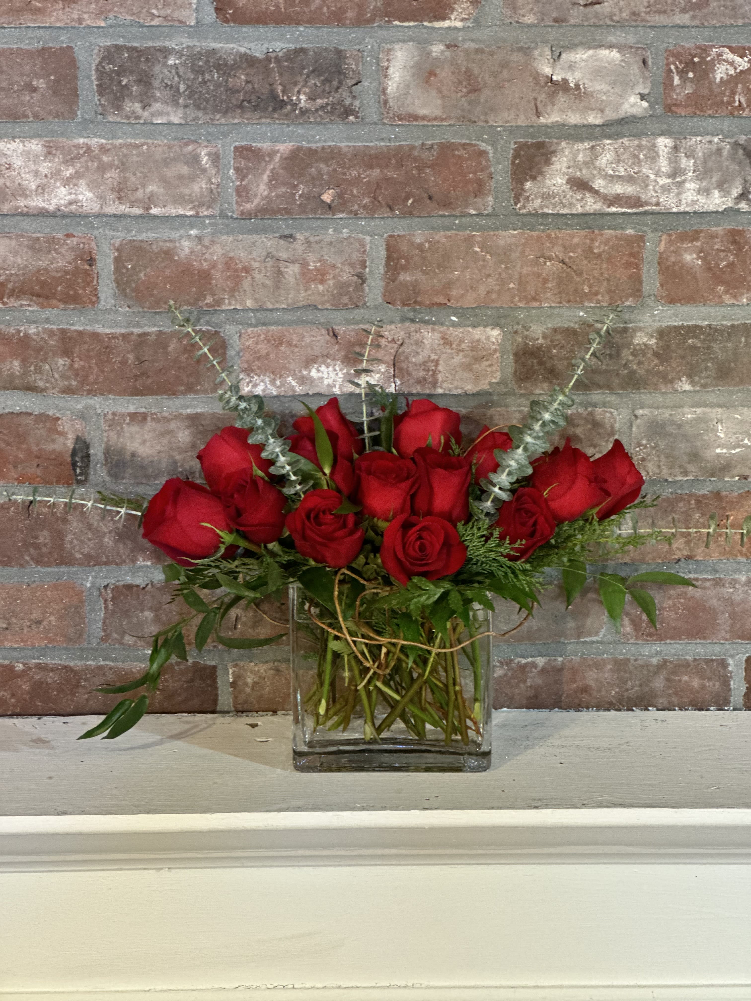 Modern Love - Our Valentine's Day Favorite! Spruce up the table with this romantic centerpiece.  Arrangement includes compact red roses with assorted foliage.