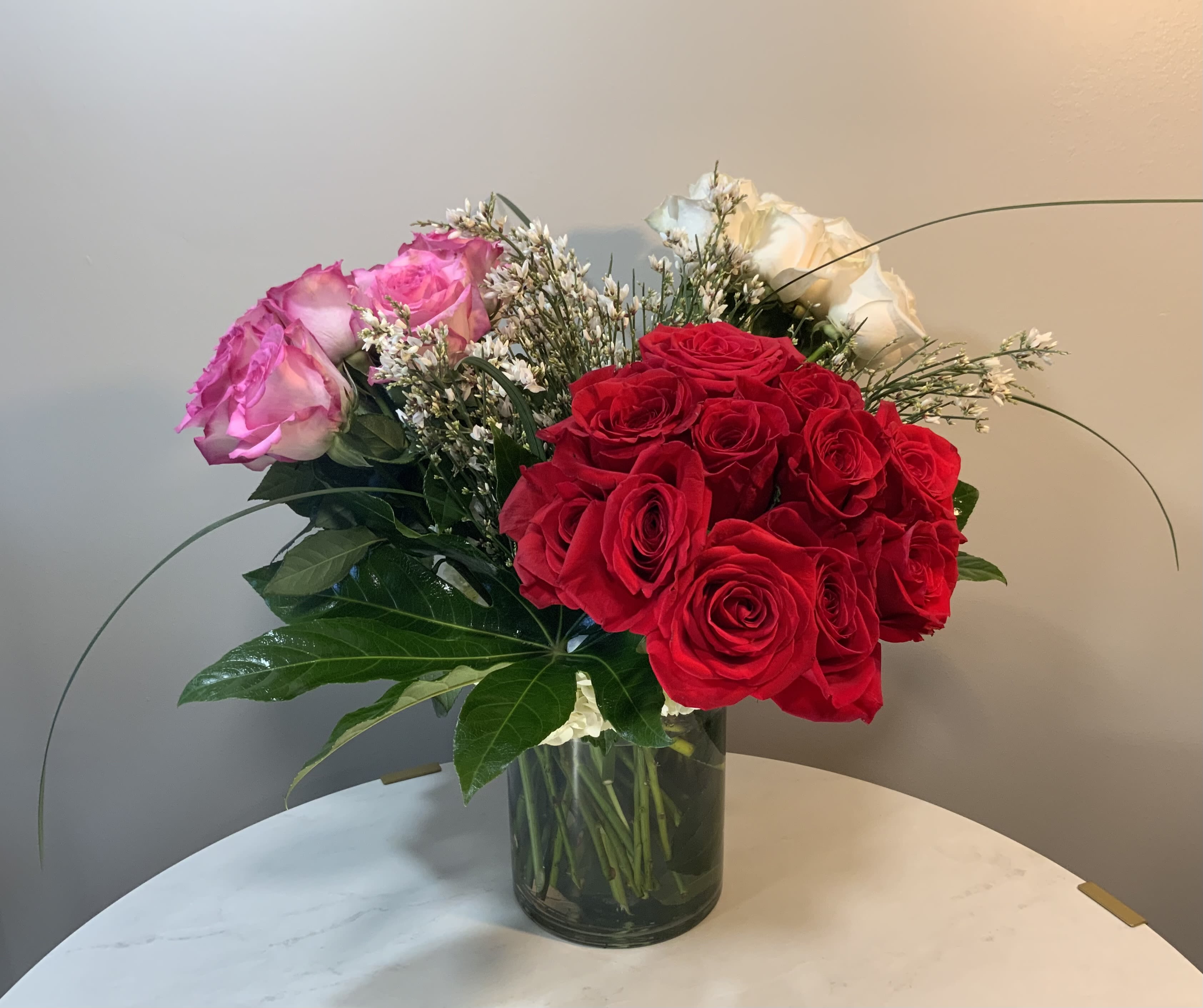 Mucho Amor  - Thirty six luscious roses, winter blooming genista and rich dark green foliages. 8 x 6 glass vase.