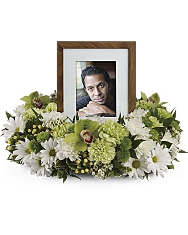 Garden Wreath - An exquisite round wreath with blooms inspired by the lasting impressions a loved one makes on our lives. Surround a treasured photograph, poem or other dear memento with sweet, green carnations, white and green chrysanthemums and the special beauty of green cymbidium orchids.This luxurious wreath includes flowers such as carnations, chrysanthemums, silky green cymbidium orchid blossoms and variegated greenery. Please note: Arrangement does not include picture frame. Approximately 20" W x 15" H