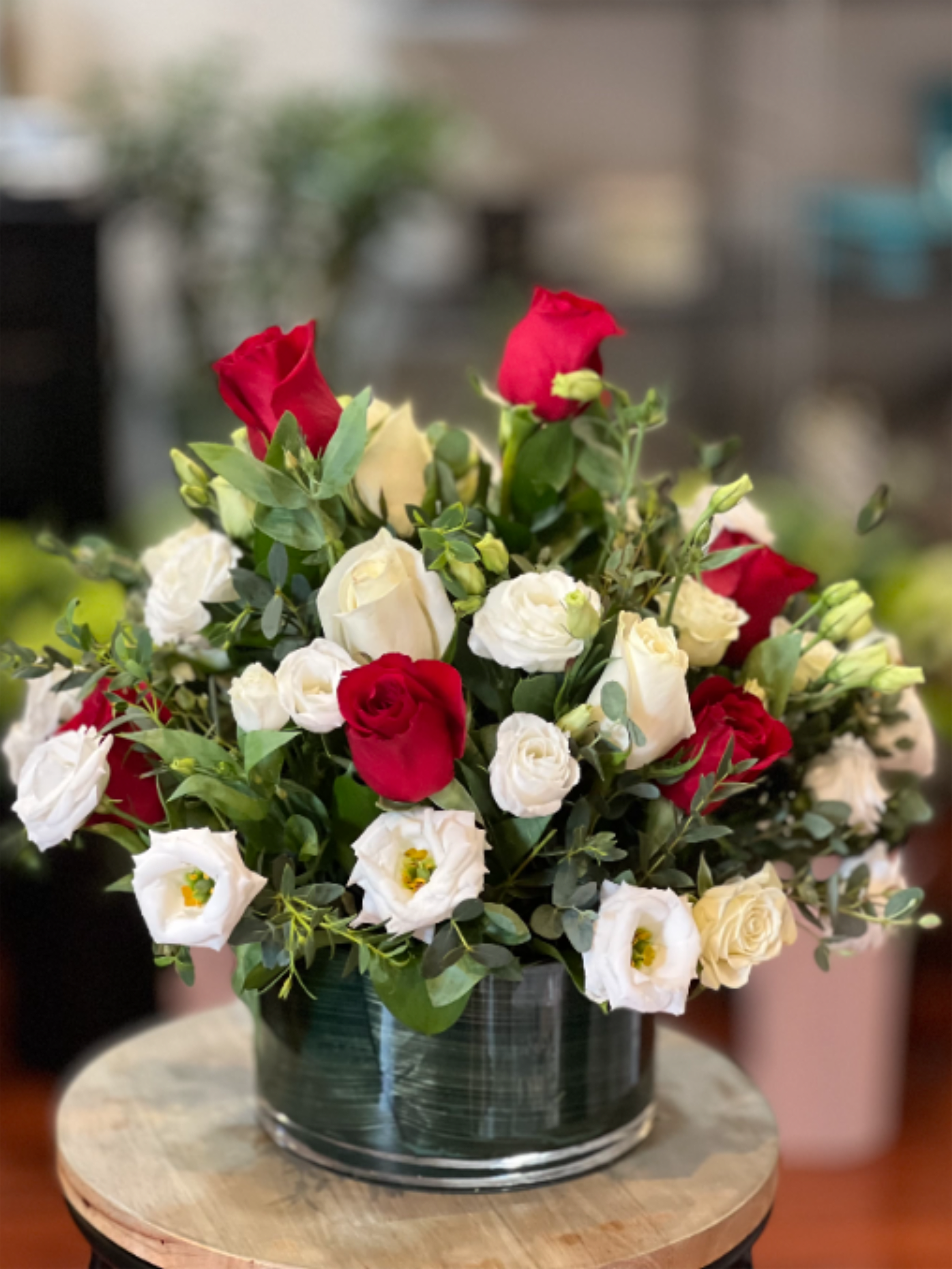 Eternal Bloom - Serenade your love with this beautiful bouquet of red and white roses! Designed with premium red roses and elegant white lisianthus in a leaf-lined cylinder vase, this arrangement is sure to capture anyone’s heart.