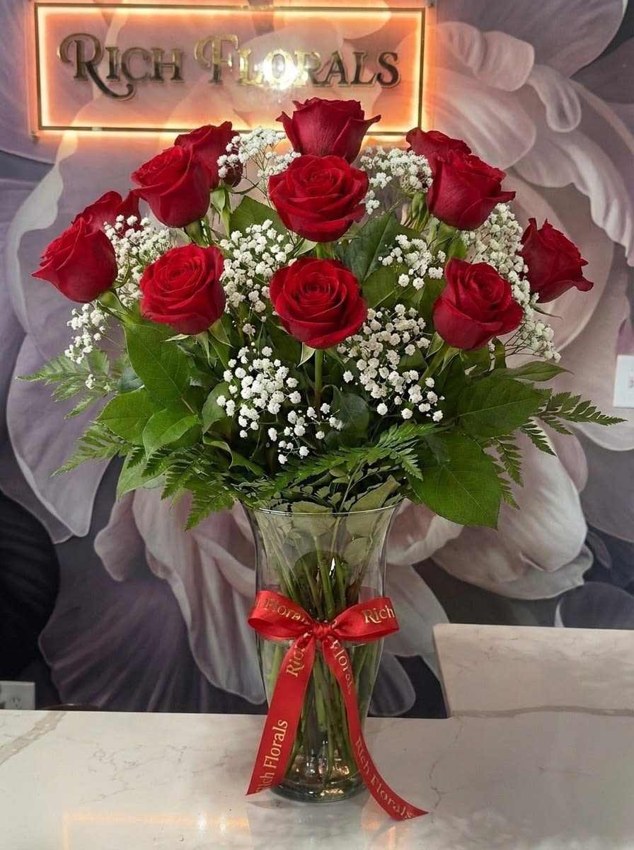 Long Stemmed Red Rose Arrangement - Dive into the classic beauty of our Dozen Long Stem Red Roses with baby's breath, each thoughtfully arranged in a timeless vase. These iconic blooms are symbols of love and devotion, with their deep red hues telling a story of profound affection. Ideal for conveying heartfelt emotions or marking memorable moments, this bouquet adds a touch of timeless charm to any celebration.  