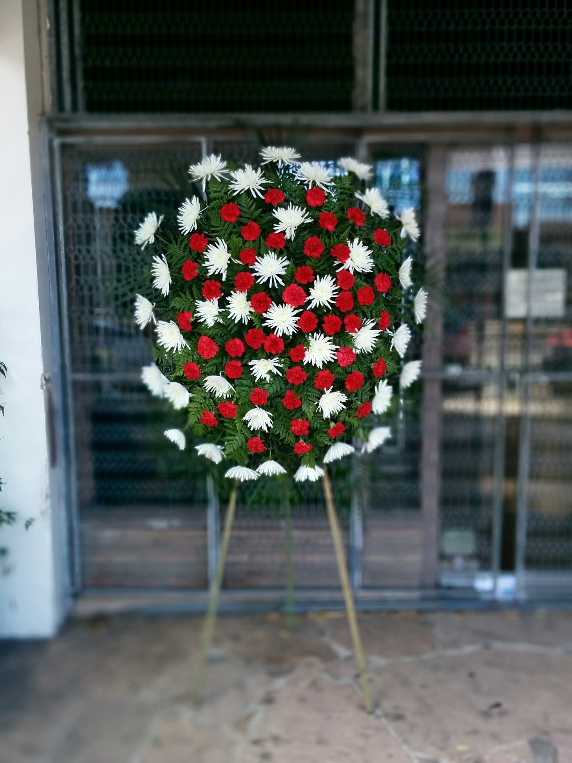 Eternal Home Spray - Eternal Home Standing Spray includes: Red Carnation White Chrysanthemum  This type of design is usually approximately 5 - 6 ft tall and is meant for funeral services ONLY. This design includes a free banner (please include a banner sign in the Special Instruction Box or Message Box with the title “BANNER”).  In the event a banner space is left blank for any reason, ONLY a card message will be included. Banners are printed in a black 2.5-inch wide ribbon with silver ink. Currently, we don't offer any other colors. If the service is the same day as the order was placed we cannot guarantee delivery by a certain time. And flowers will be delivered during normal business hours.  To ensure the delivered flowers match the displayed photo as close as possible we recommend ordering 3-5 days in advance. For the same or next day deliveries, we reserve a right to substitute flowers with the same or greater value.