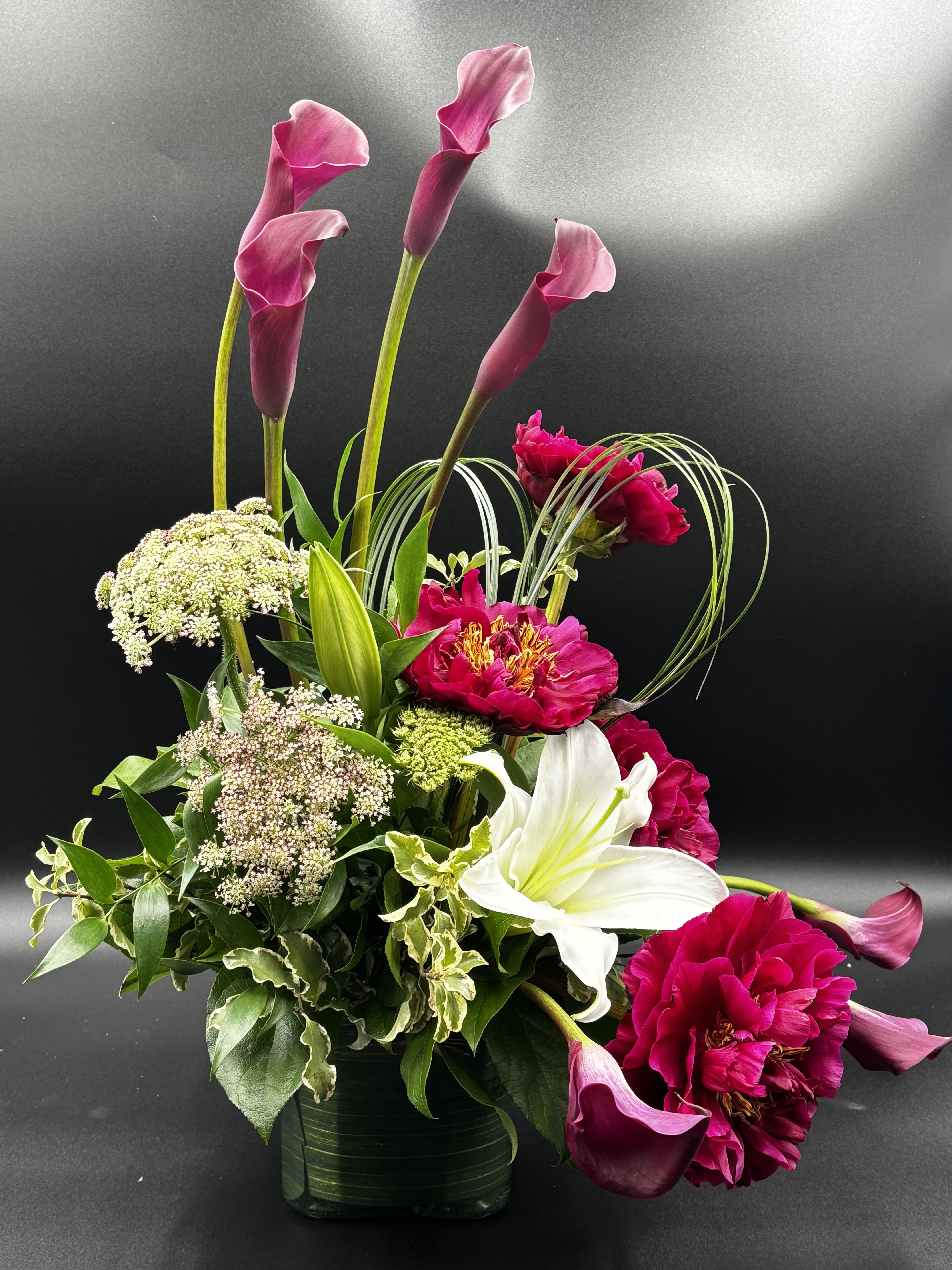 Endless Devotion - Show the love of your life just how much you love them. This arrangement, Endless Devotion is the purest example of how deep your love is with Burgundy Cala Lilies, Burgundy Peonies and the Asiatic Lily. Perfect for any Anniversary, Valentines Day, or just to express your Endless Devotion.   ** Due to flower availability this arrangement requires at least a week advance order ** Approximate Dimensions: 23"H X 18" W