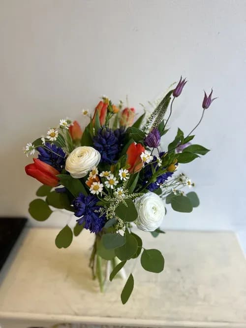 B+ Valentine's 23 - A perfect surprise on a special day to a special person.  A hand tied bouquet with a unique combination of orange tulips and purple hyacinth along with a touch of filler flowers.  Depending on availability flowers may change.