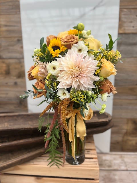 Golden Glow - A warm and cheerful bouquet with soft pastels and golden tones, accented by fresh greenery and finished with a flowing ribbon.