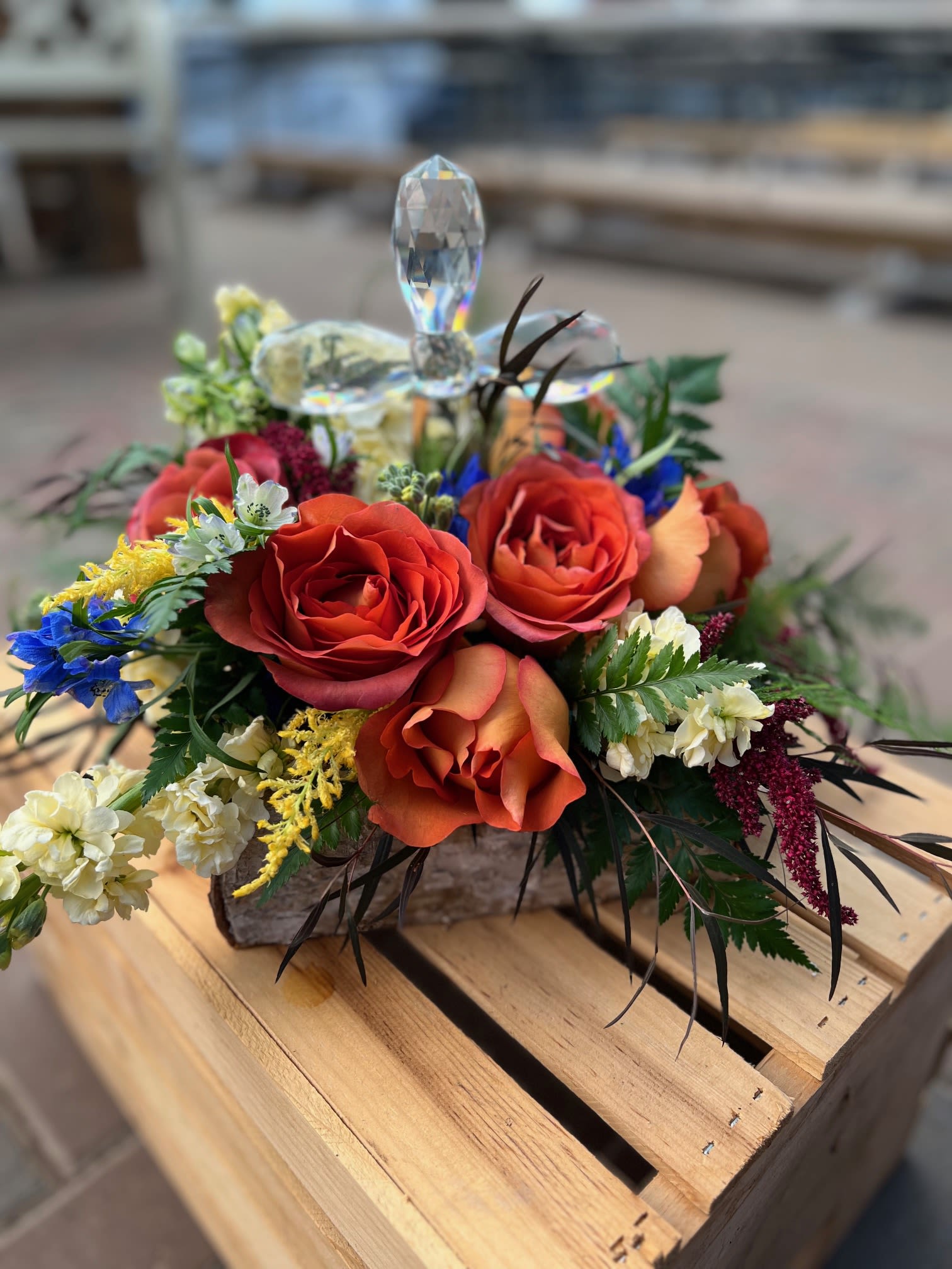 Memories Again - Honor a loved one with a mix of blooms and crystal cross. 