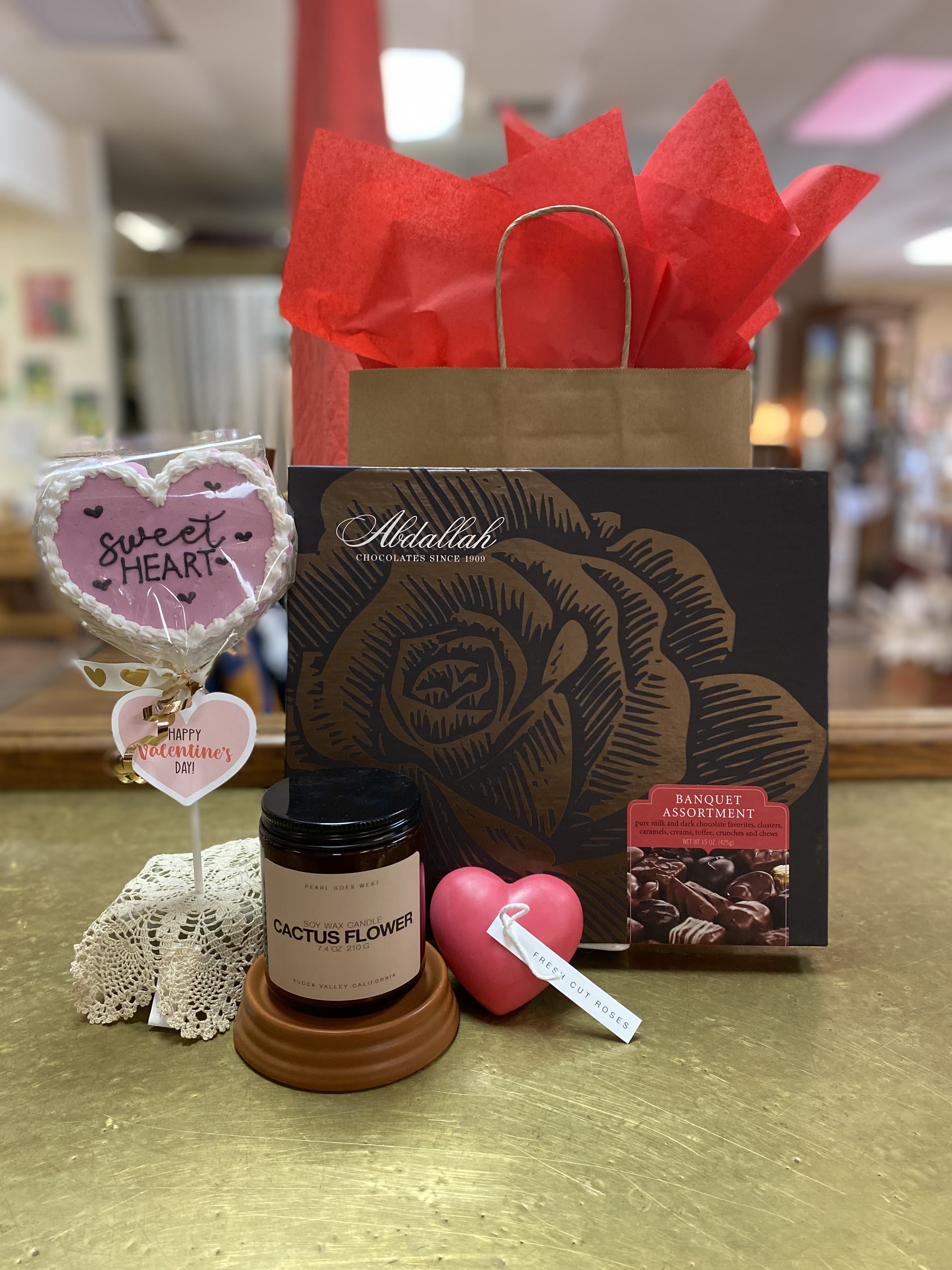 Extra Sweet Bundle - Surprise your special someone with this EXTRA sweet bundle! Includes a large box of assorted, delectable Abdallah chocolates, a handmade frosted sugar cookie "pop" from Desert Baked and a warm, locally made, amber jar candle, PLUS a heart shaped candle. Items will come wrapped in tissue and gift bag. PLEASE SPECIFY which cookie pop from the pictures you would prefer. Items are limited stock.