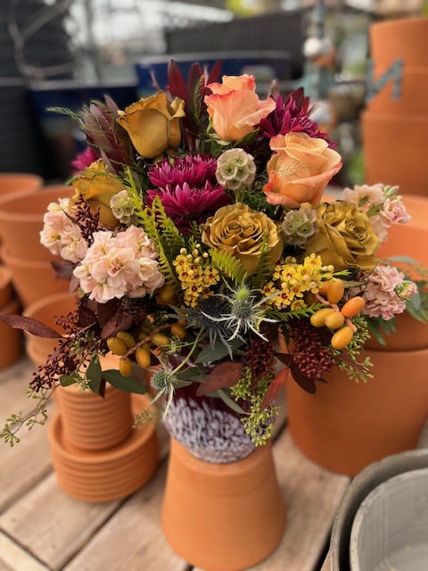 True Colors - A vast array of color is found in this arrangement, from roses, wax flowers, and stock to scabiosa pods and a variety of seeded eucalyptus. 