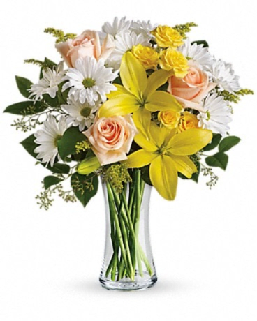 Daisies and Sunbeams - The song says, "The sun'll come out tomorrow," but why not today? Whatever the weather, this sunny bouquet of yellow, peach and white flowers will brighten any day instantly. Perfect for a birthday, thank you or just because. This sunny bouquet includes peach roses, yellow spray roses, yellow asiatic lilies, white daisy spray chrysanthemums and solidago accented with assorted greenery. Delivered in a glass gathering vase.