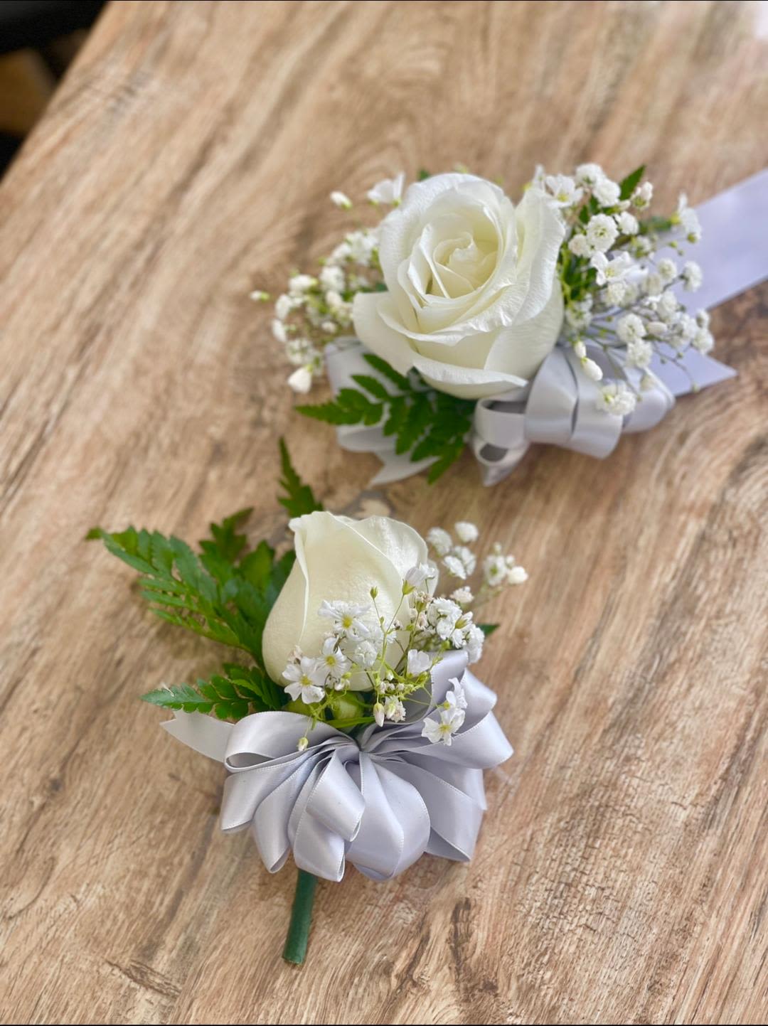 Nature Elegance Corsage and Boutonniere Set  - Made from fresh flowers, a corsage looks like a petite flower arrangement (typically consisting of just one or several smaller blooms) and usually sits on the wrist like a bracelet, though it can also be pinned on a lapel. Corsages serve as a way to honor people who are very important to the couple getting married. Please contact our shop at (747) 249-4678 for any customization. 