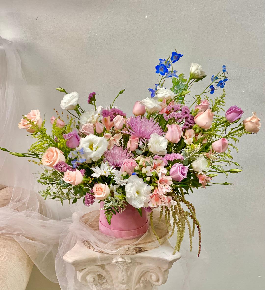 Niloo - Product Information:   Theme Colors: Shades of, Pink, white, lavender&amp; Blue.  Featured: Blooms: Roses, Delphinium, Chrysanthemums, Lisi Antus, Alstroemeria, with seasonal blooms.  HK Flowers have a uniqueness of florals and seasonal blooms, certain flowers or colors may not be available as each season affects the availability, color, size, and shape of each floral bloom. Some flowers may be substituted accordingly.  Photos are used as a reference for the color palette and is NOT indicated of the final product. We ask for your trust in us that we will pick out the best seasonal available blooms, while still capturing the arrangements' theme and colors mentioned above.