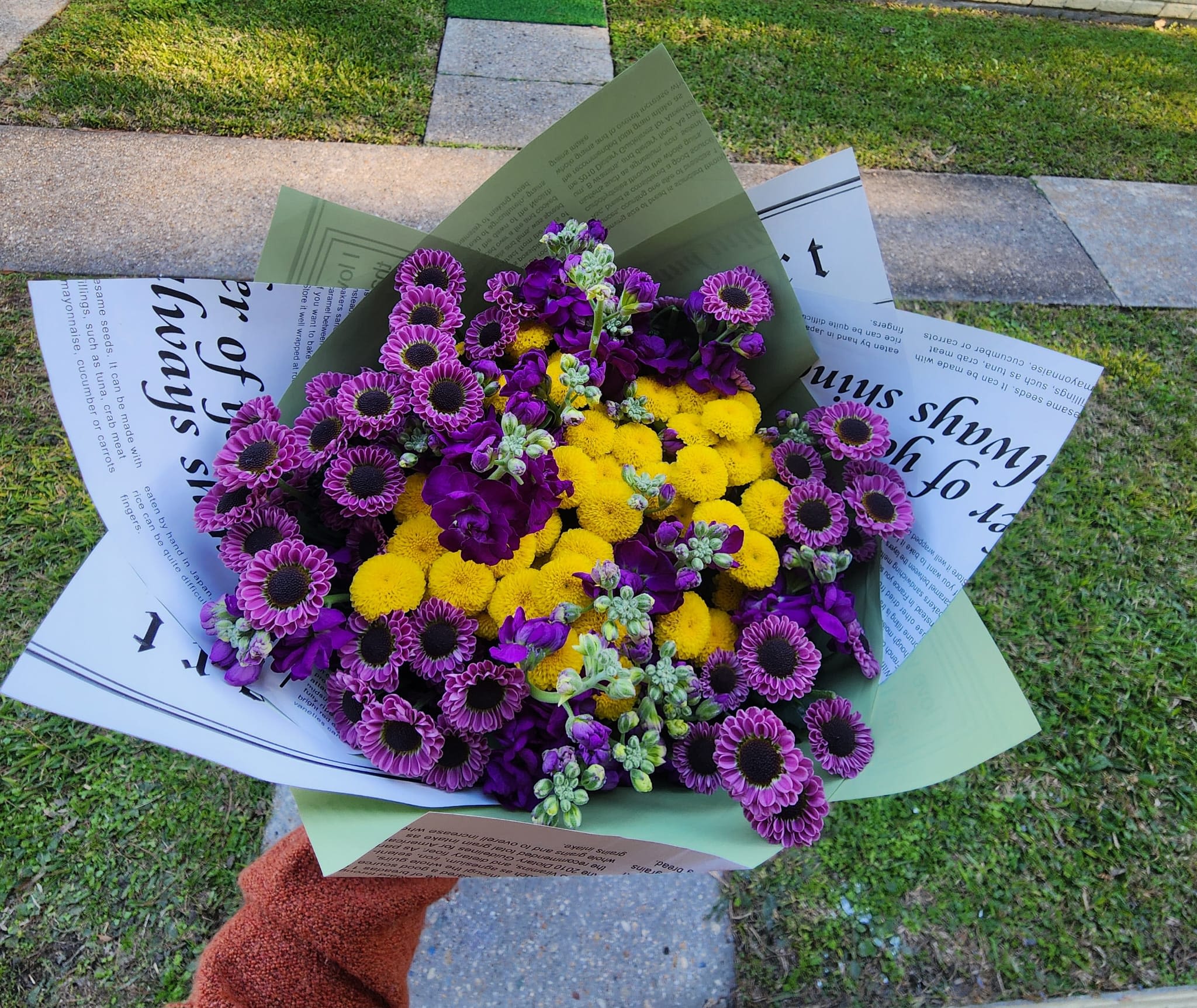 Jubilee - Bursts with Mardi Gras spirit, an unapologetic celebration of color and joy. Vibrant royal purple blooms getting along with a radiant core of golden yellow flowers, creating a bold contrast; made to turn heads and lift spirits.