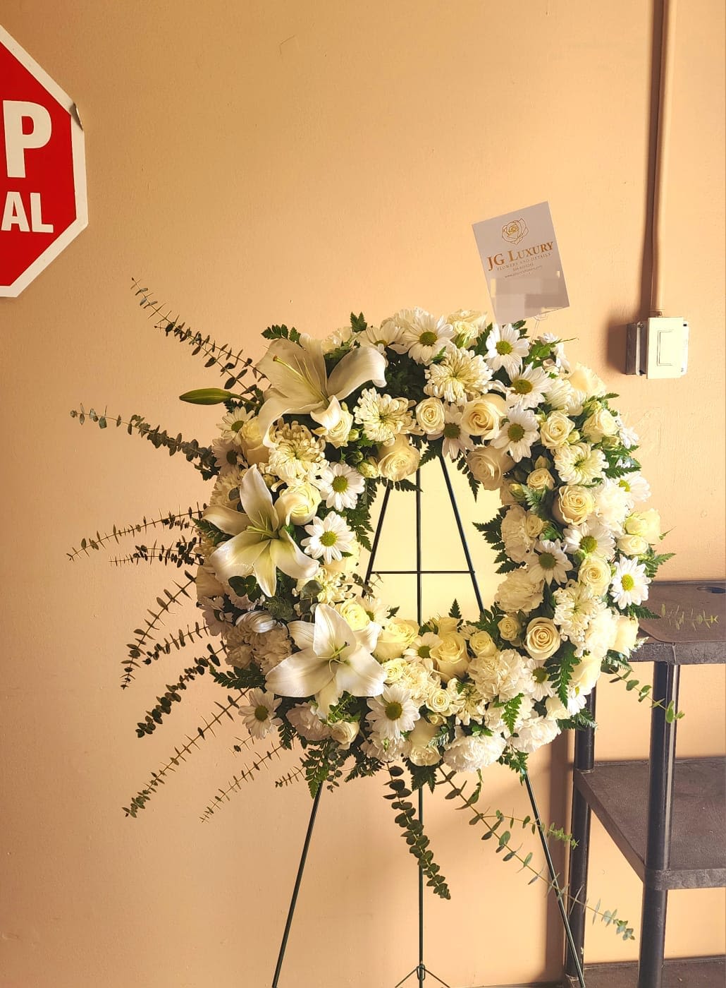 Lasting Serenity by BloomNation™  - A beautiful white and green tribute wreath that calms, this easel arrangement celebrates a full life and a peaceful passing. 