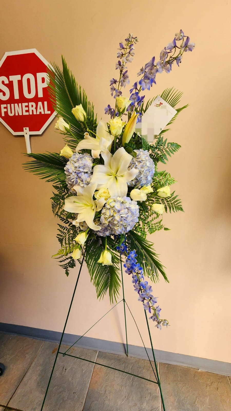 Ocean Breeze Spray  - Includes blue hydrangea, white roses, delphinium, asiatic lilies, along with tropical ferns and leaves.