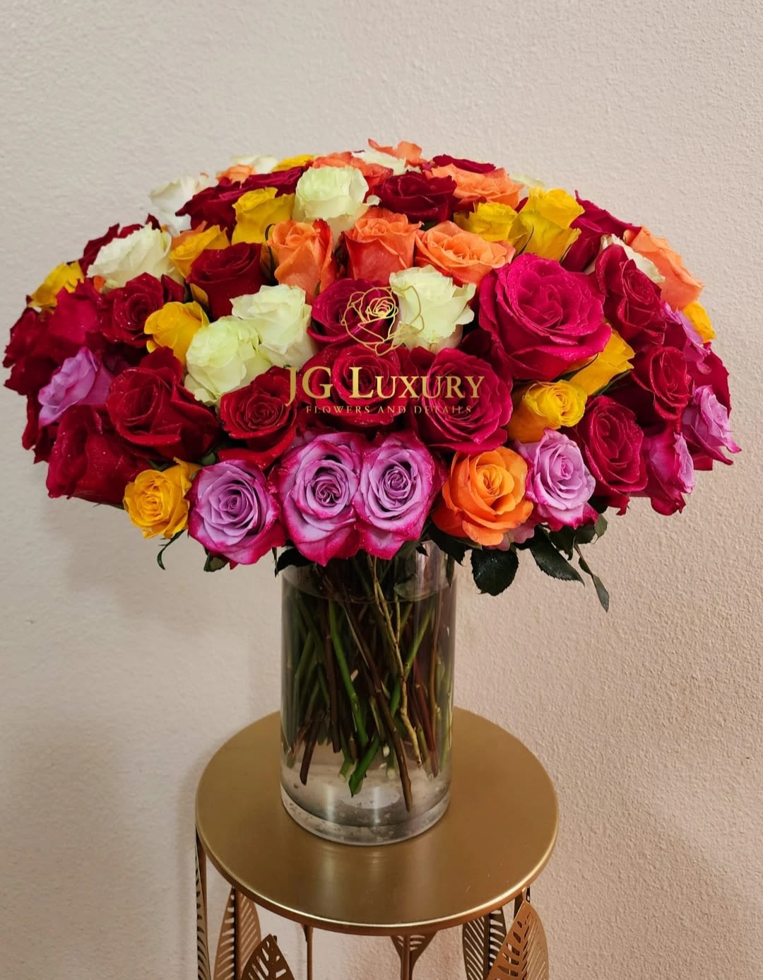 Symphony of Roses - Celebrate life’s most cherished moments with this exquisite floral arrangement featuring one hundred vibrant roses in a stunning array of colors. Each bloom is carefully selected to create a breathtaking harmony of colors which may vary, but the essence wil remain, arranged in a sleek glass vase.