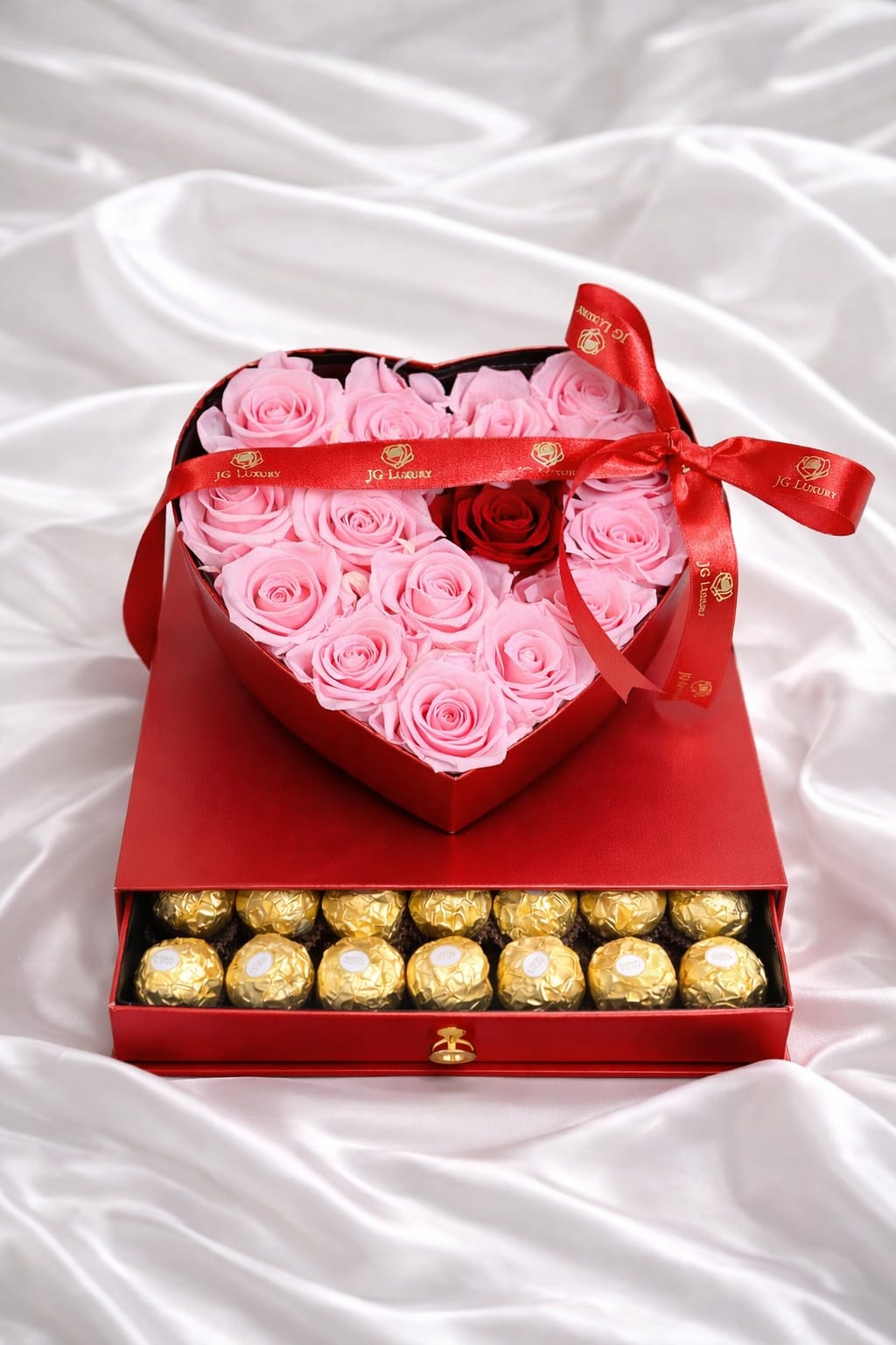 Sweet Love - Red heart shaped box filled with soft pink natural roses and a single red natural rose at the center, tied with an elegant red ribbon, filled with Ferrero Rocher chocolates.