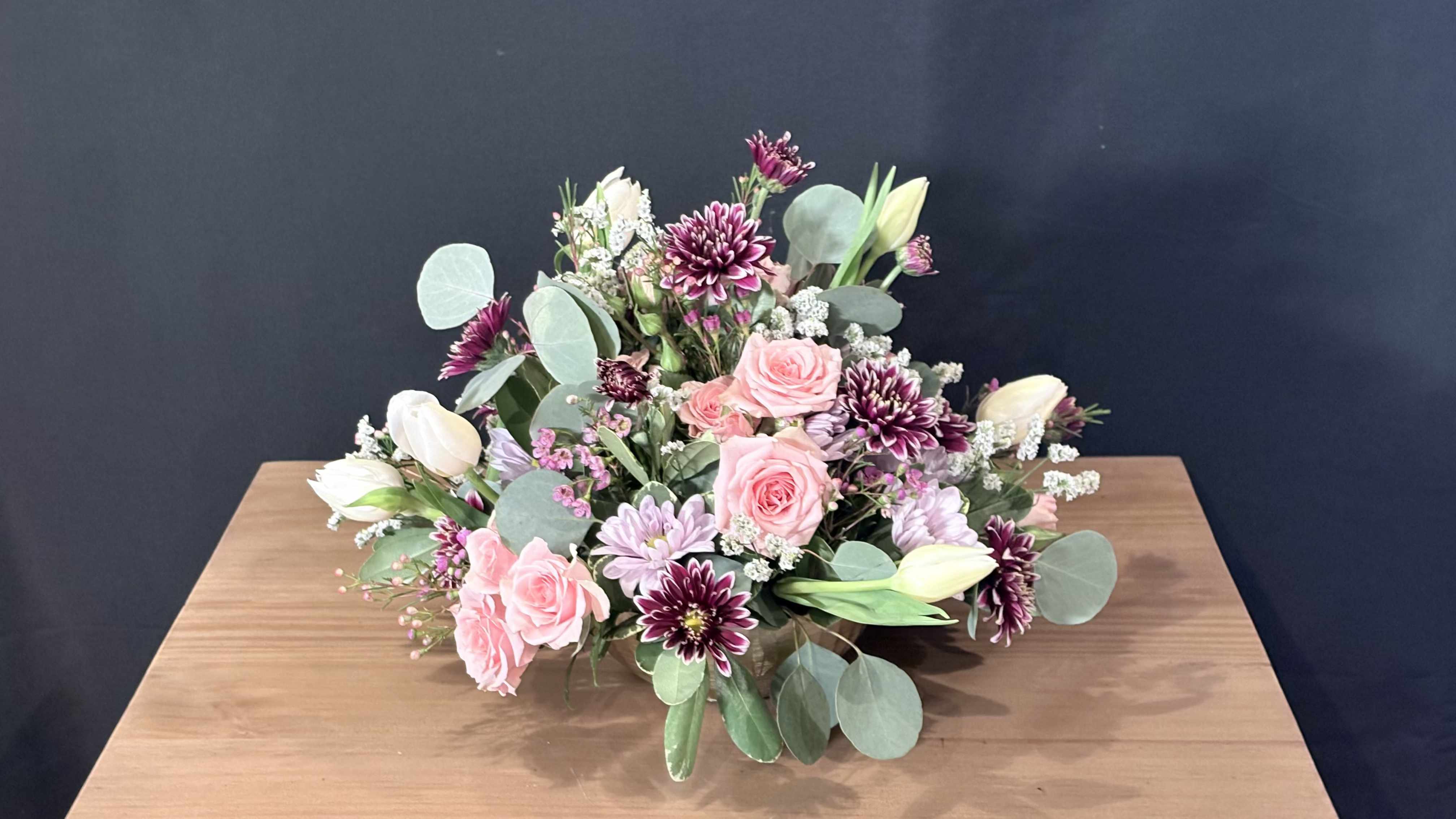 Spring Stepping - A lush arrangement of seasonal blooms artfully gathered to create a soft, romantic statement. Delicate petals, graceful textures, and harmonious colors come together in a timeless design that feels both refined and heartfelt.
