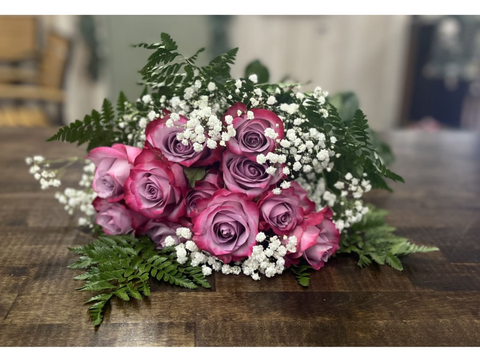 Dozen Color Roses Wrapped - A dozen roses of a designer's choice color wrapped with greens and filler and finished with a ribbon. This is a wonderful ode to love. Please note that this product does not come in a vase. Stems will have sponge water source to keep hydrated