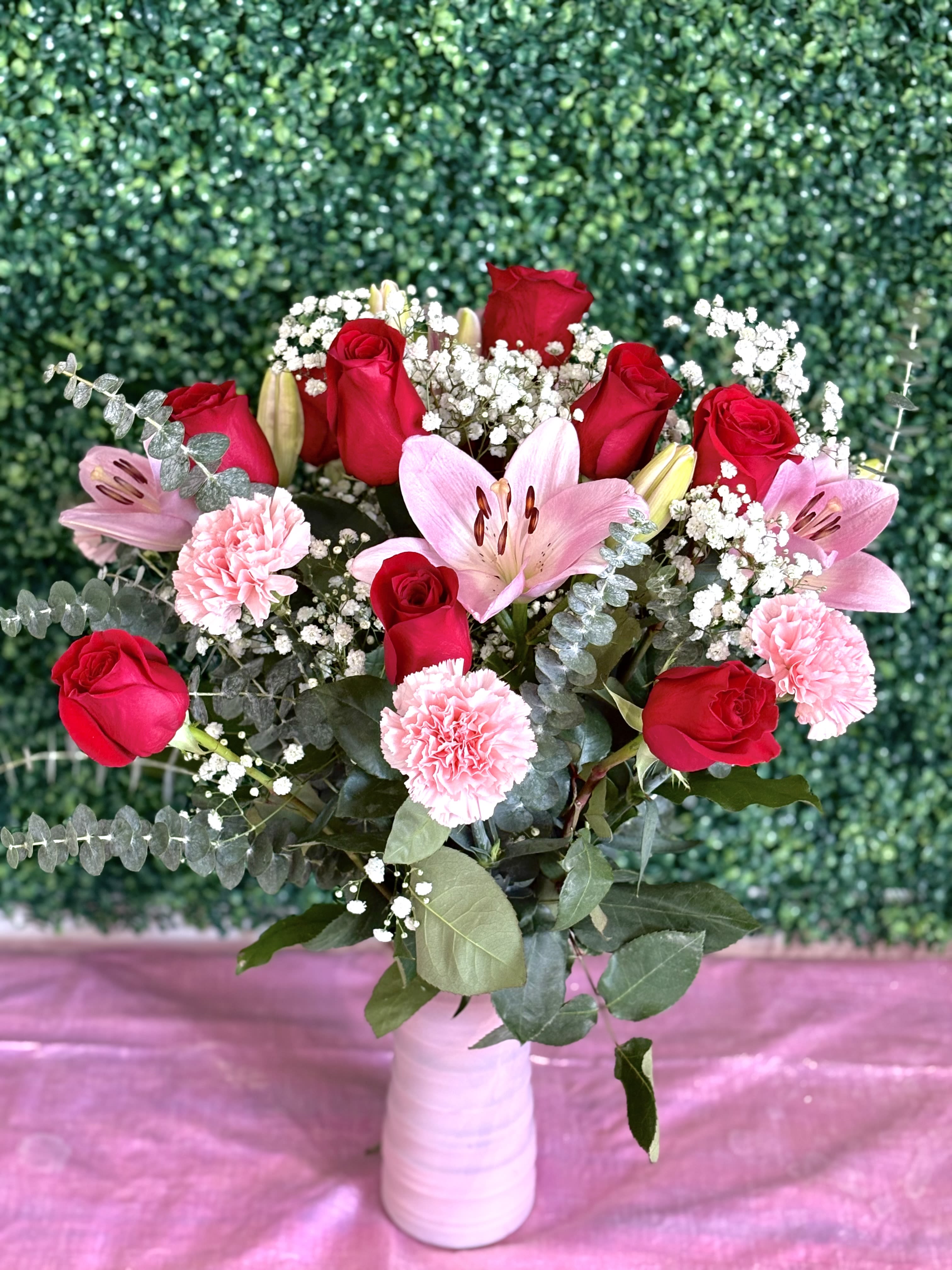 Rose and Lily Medley  - A medley of red roses, baby’s breath, pink asiatic lilies, pink carnations, and greenery arranged beautifully in a pink vase. Measures approximately 24-26 inches in height.