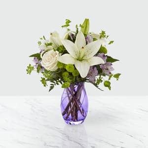 The FTD® Sense of Wonder Bouquet - FTD&reg; proudly presents the Sense of Wonder&trade; Bouquet. Boasting a truly charming collection of blooms that is set to surprise and delight your special recipient, this fresh flower arrangement has a light and airy look to it that is set to capture their hearts and imagination. Cream roses, mingle with lavender Peruvian Lilies, showy and fragrant white Asiatic Lilies, green button poms, lavender statice, bupleurum, and lush greens to create an inviting springtime look. Presented in a stylish lavender glass vase to give this flower bouquet an extra pop of color, this arrangement looks like it's been taken straight from the pages of Better Homes and Gardens&reg; to create that perfect Mother's Day, thank you, or happy birthday gift. GOOD bouquet is approximately 14"H x 12"W. BETTER bouquet is approximately 14"H x 14"W. BEST bouquet is approximately 16"H x 15"W. z