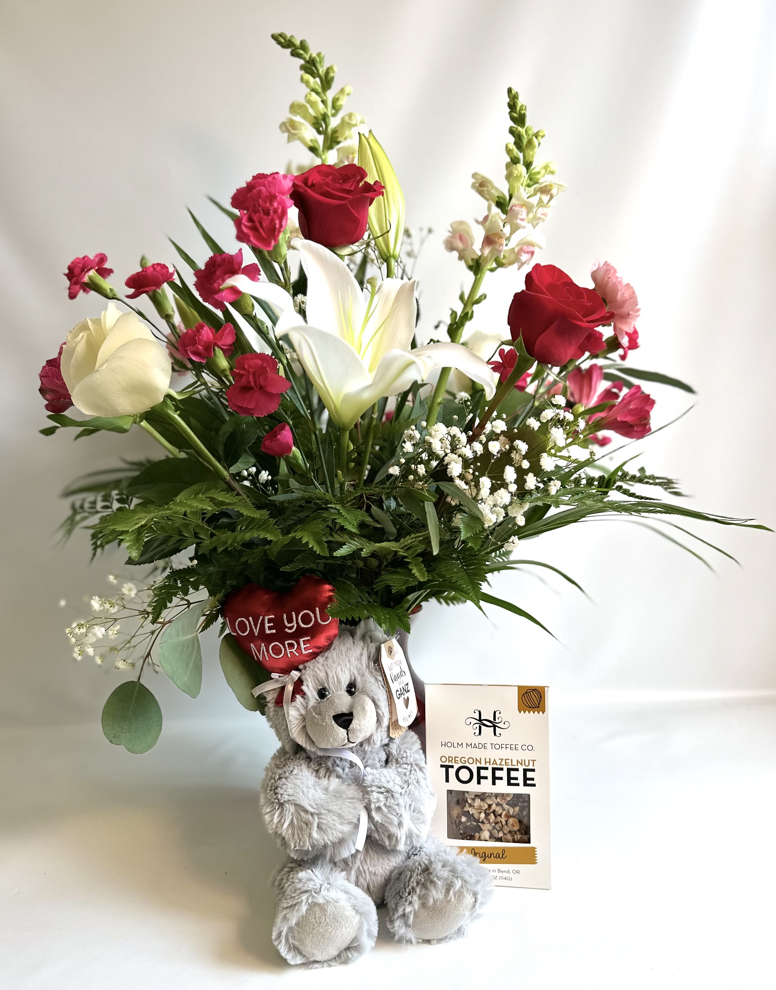 Hello Beautiful by Barb’s Flowers - This red vase is filled with lilies, roses, carnations, mini carnations and snapdragons. Comes with Toffee and a Ganz Brand Bear holding a heart balloon. 