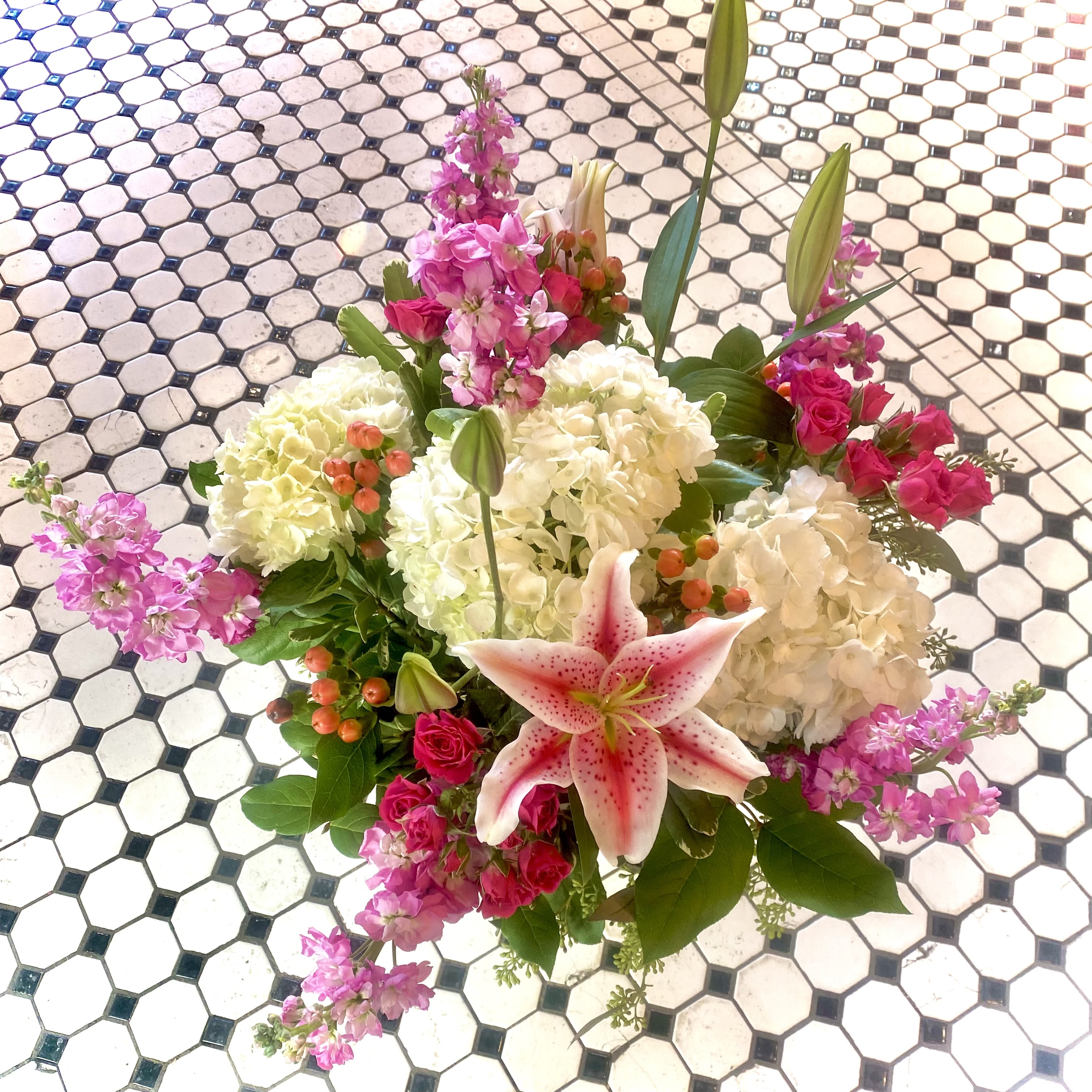 Valentine's Pretty n' Pink - So pretty, this romantic &amp; lush arrangement is presented in a clear glass vase. Valentine's Pretty in Pink will convey beauty overflowing with spray Roses,  Hydrangea, Lilies, berries and an array of pink flora. This arrangement sits approx. 19 inches tall and 20 inches wide
