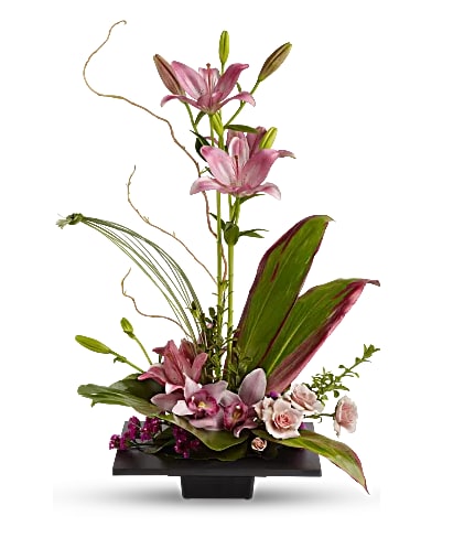 Imagination Blooms Tropical Arrangement - This composition of pink lilies, pink orchids and pink roses is memorably tranquil. A modern, square black dish is filled with just the right number of Zen tropical flowers, grasses and leaves. The exotic bouquet includes orchids, light pink spray roses, pink Asiatic lilies and  statice accented with ti leaves and other assorted greenery. Approximately 23 1/2" W x 27" H