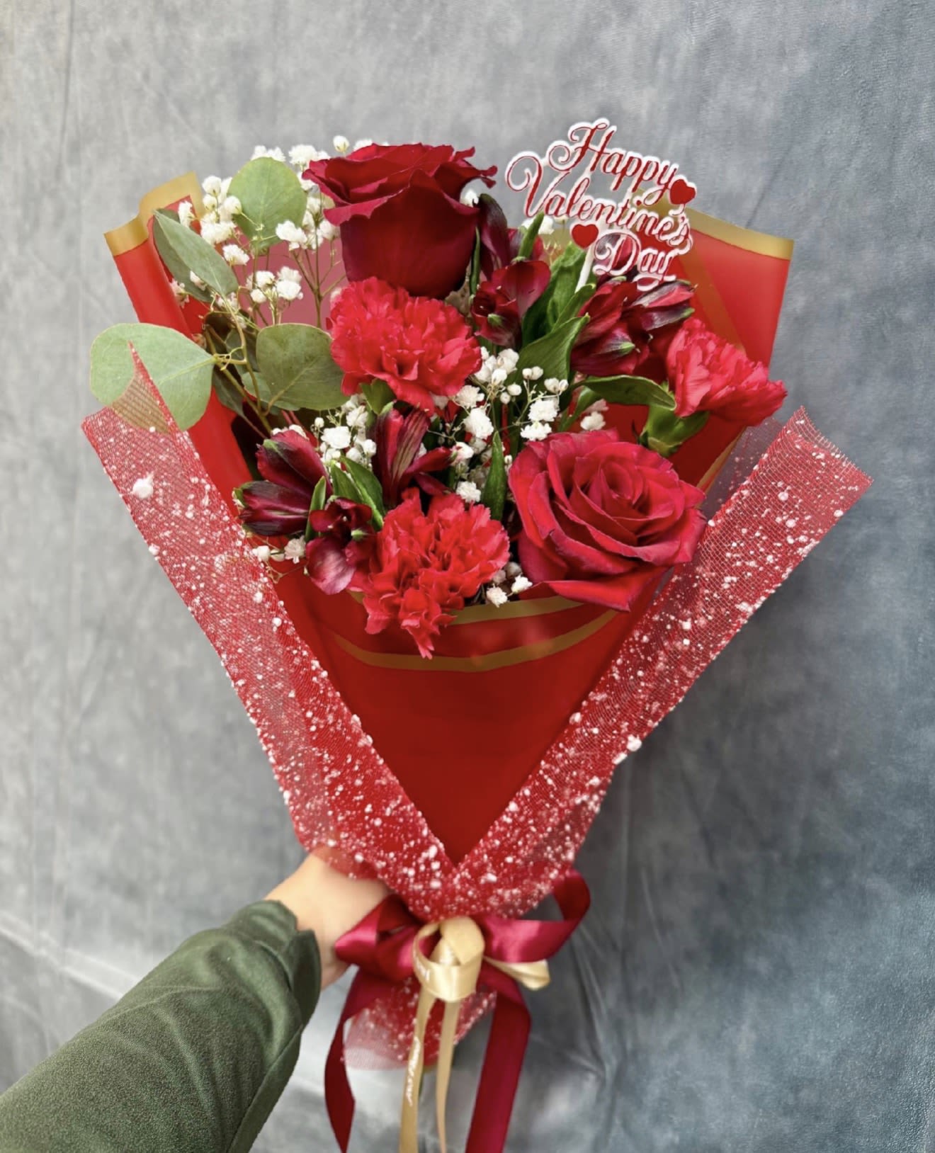 Mix Red Layered Bouquet  - A romantic hand-tied bouquet featuring rich red roses, carnations, and alstroemeria, delicately accented with baby’s breath and lush greenery. Wrapped in elegant deep-red paper for a bold, timeless statement of love and passion. ️