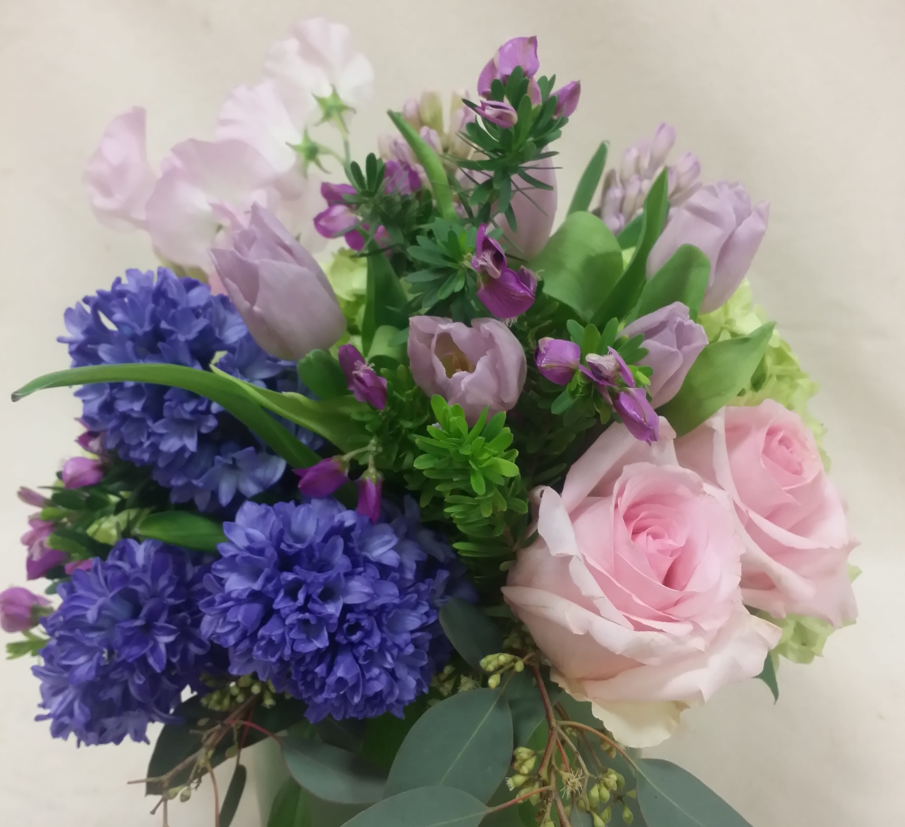 "Parisian Love" Bouquet - Deep blue hyacinth and soft pink roses are artfully arranged with pink and pale lavender accents. 