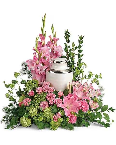 Sacred Solace Cremation Tribute - Surround the cremation urn with gorgeous, graceful pink blooms that show deep gratitude for a beautiful life.  This pretty arrangement includes miniature green hydrangea, pink spray roses, pink asiatic lilies, pink alstroemeria, pink gladioli, pink carnations, green carnations, bupleurum, green ivy, myrtle, ming fern, and lemon leaf. Arrangement does not include urn.