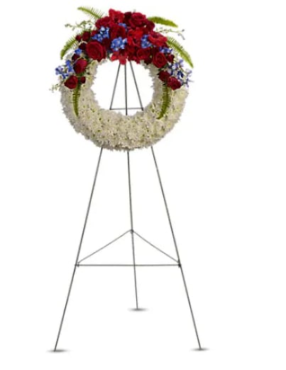 Reflections of Glory Wreath - "A stunning display of patriotism, strength and sympathy. This red, white and blue wreath delivers a lovely message about the dignity of the deceased. A lovely array of flowers such as blue hydrangea, red roses and spray roses, delicate blue delphinium, red gladioli, white cushion spray chrysanthemums and more create a circle of serene beauty.   Orientation : One-Sided  All prices in USD ($)  Standard  T241-1A"